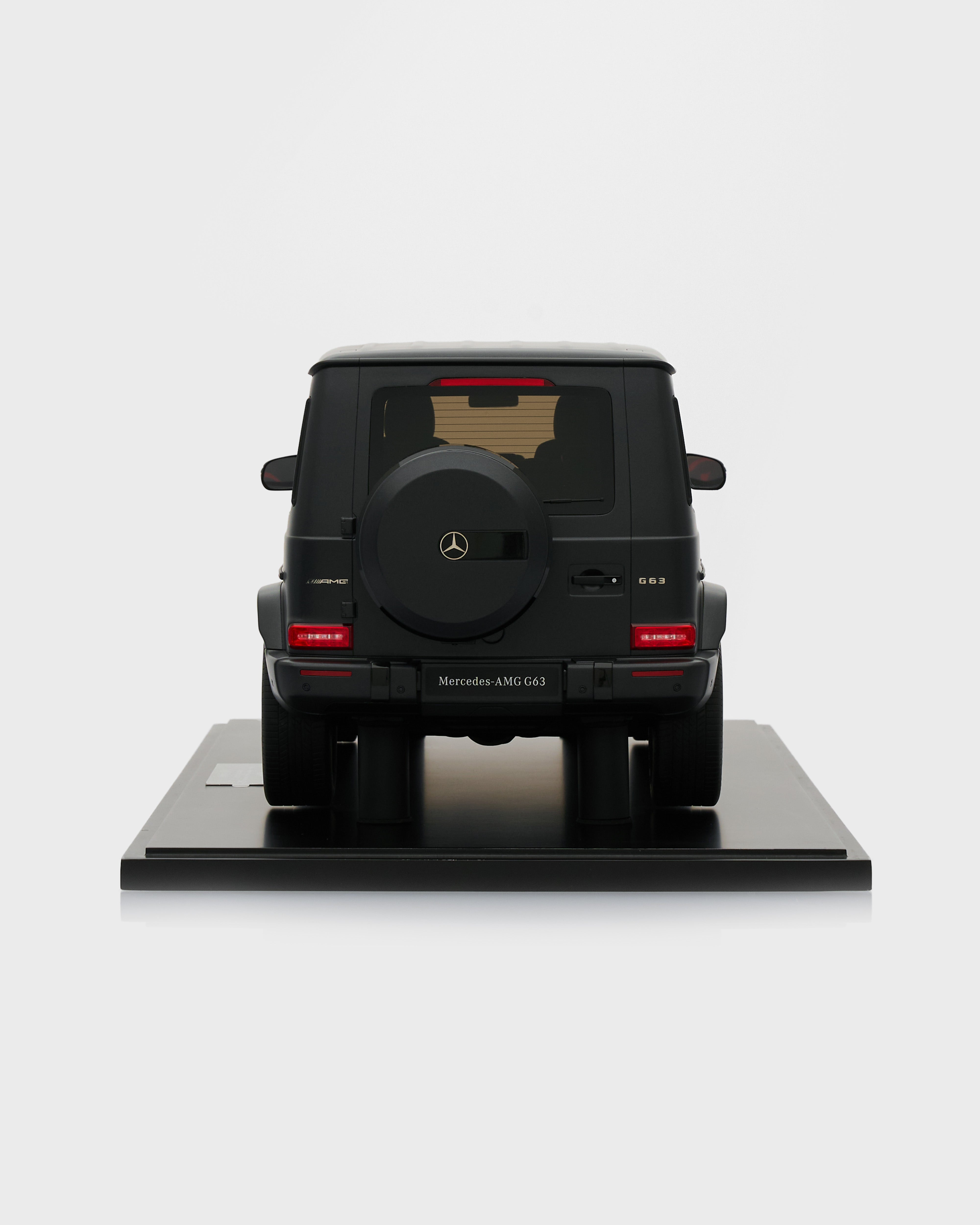 Black Mercedes-Benz model car on a white platform