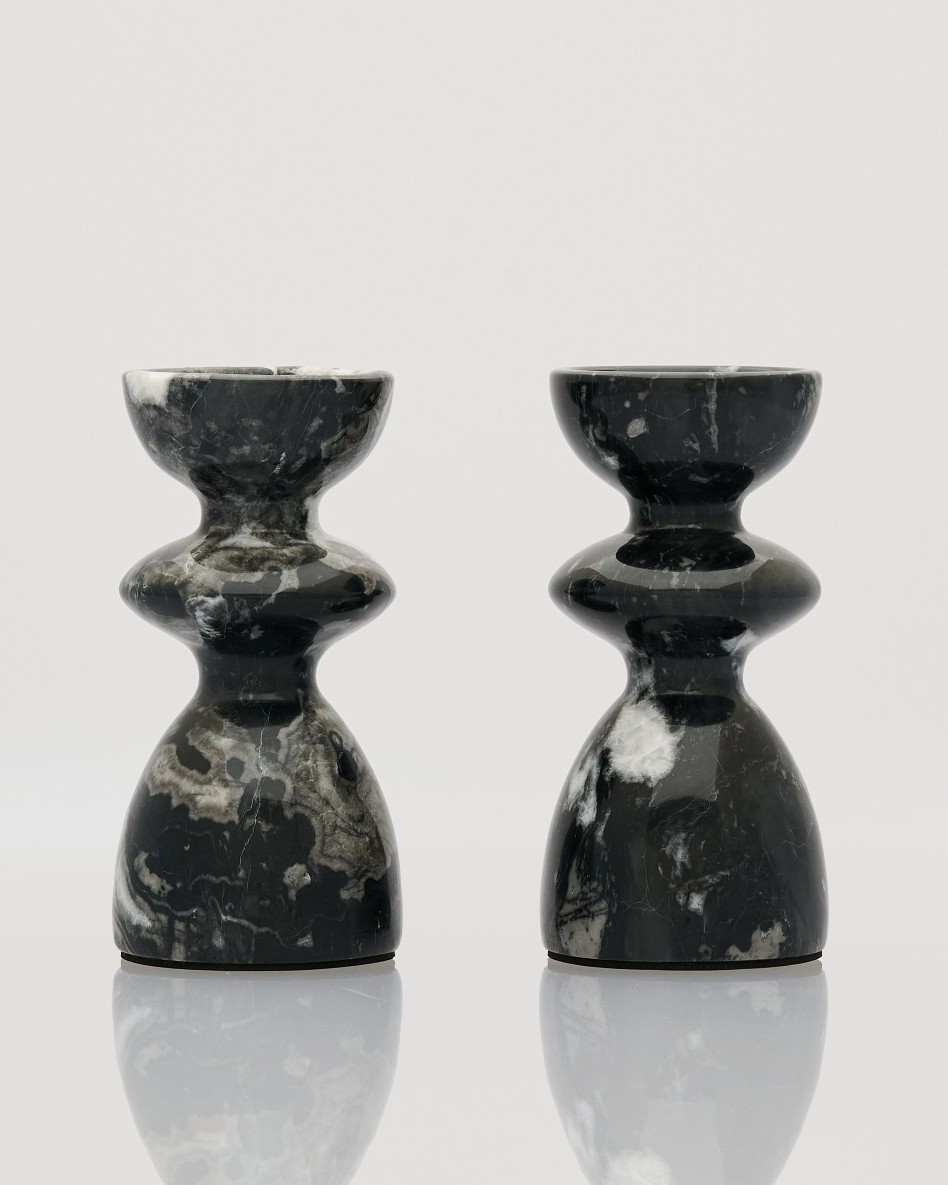 Two black marble candle holders on a white background