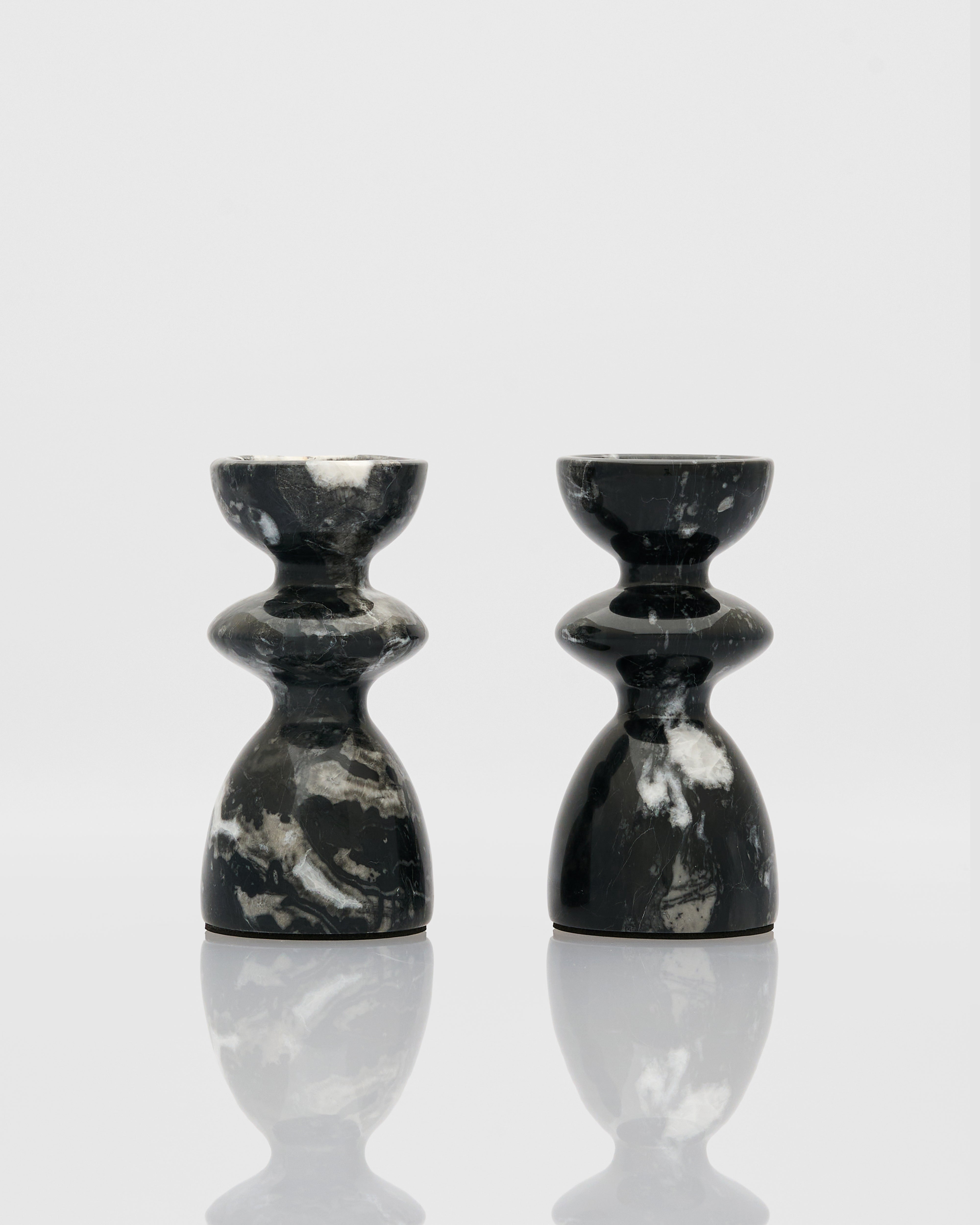 Two black marble candle holders on a white background