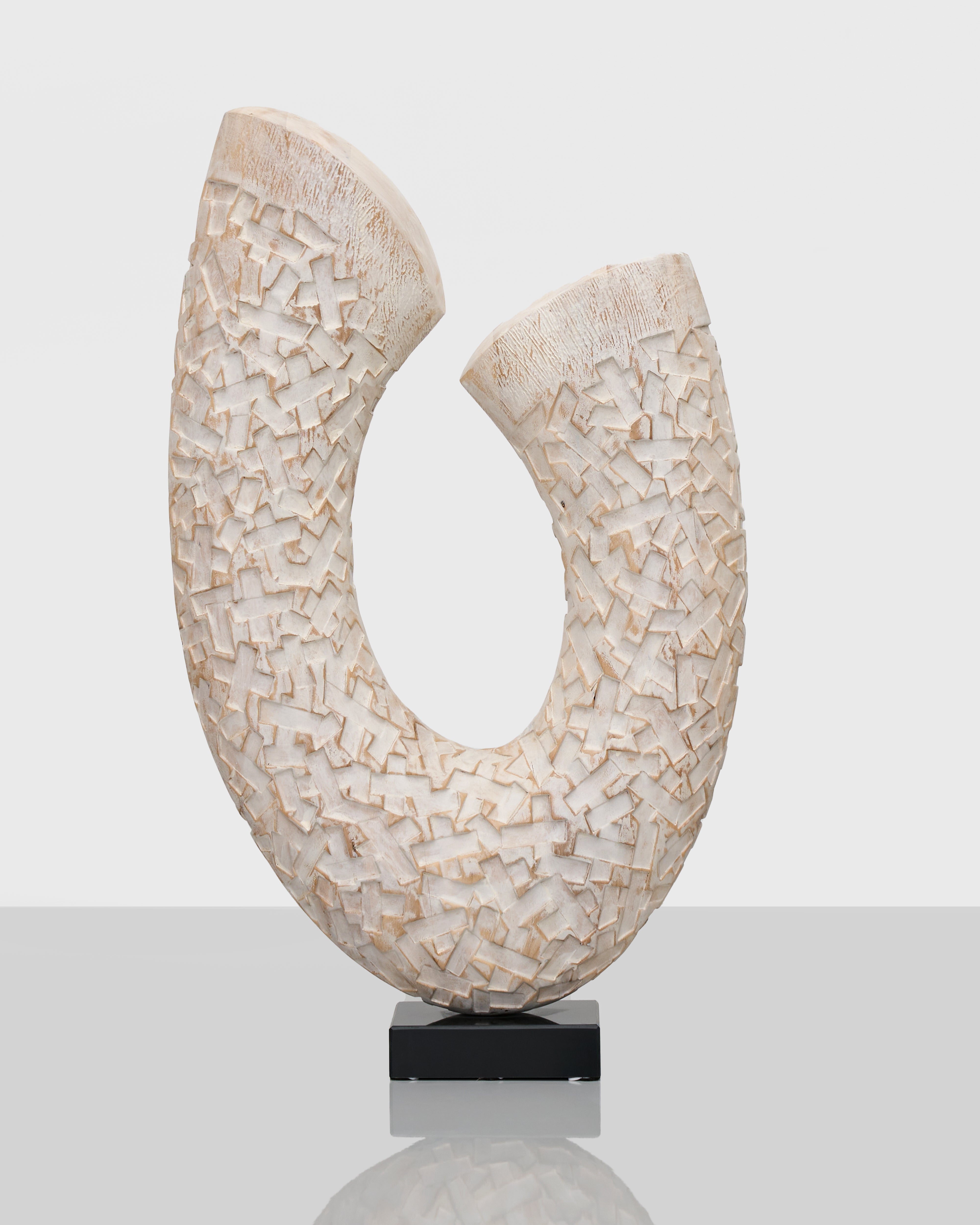 Abstract sculpture with textured surface on a white background