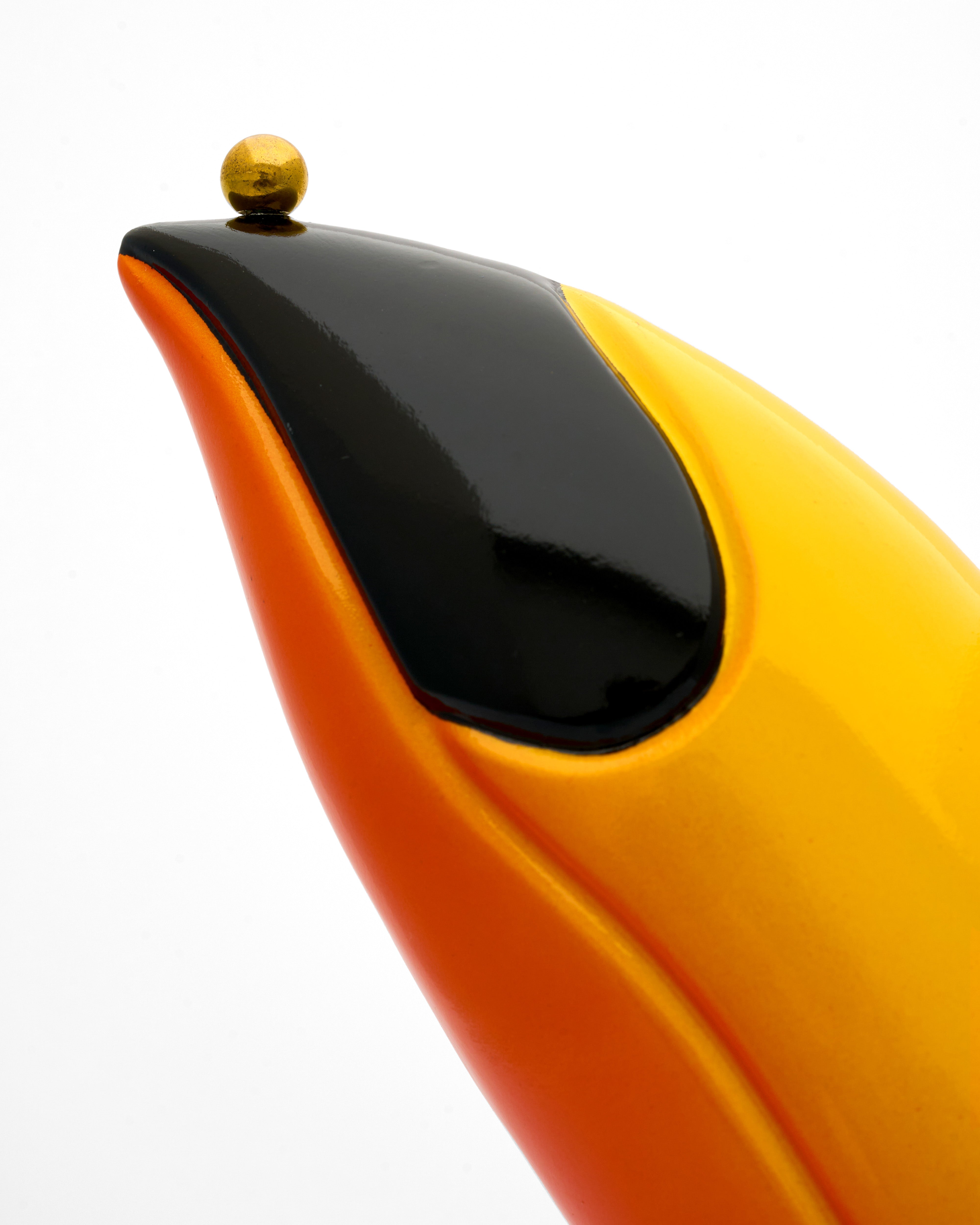 Close-up of a yellow and black beak of toucan figurine with a white background