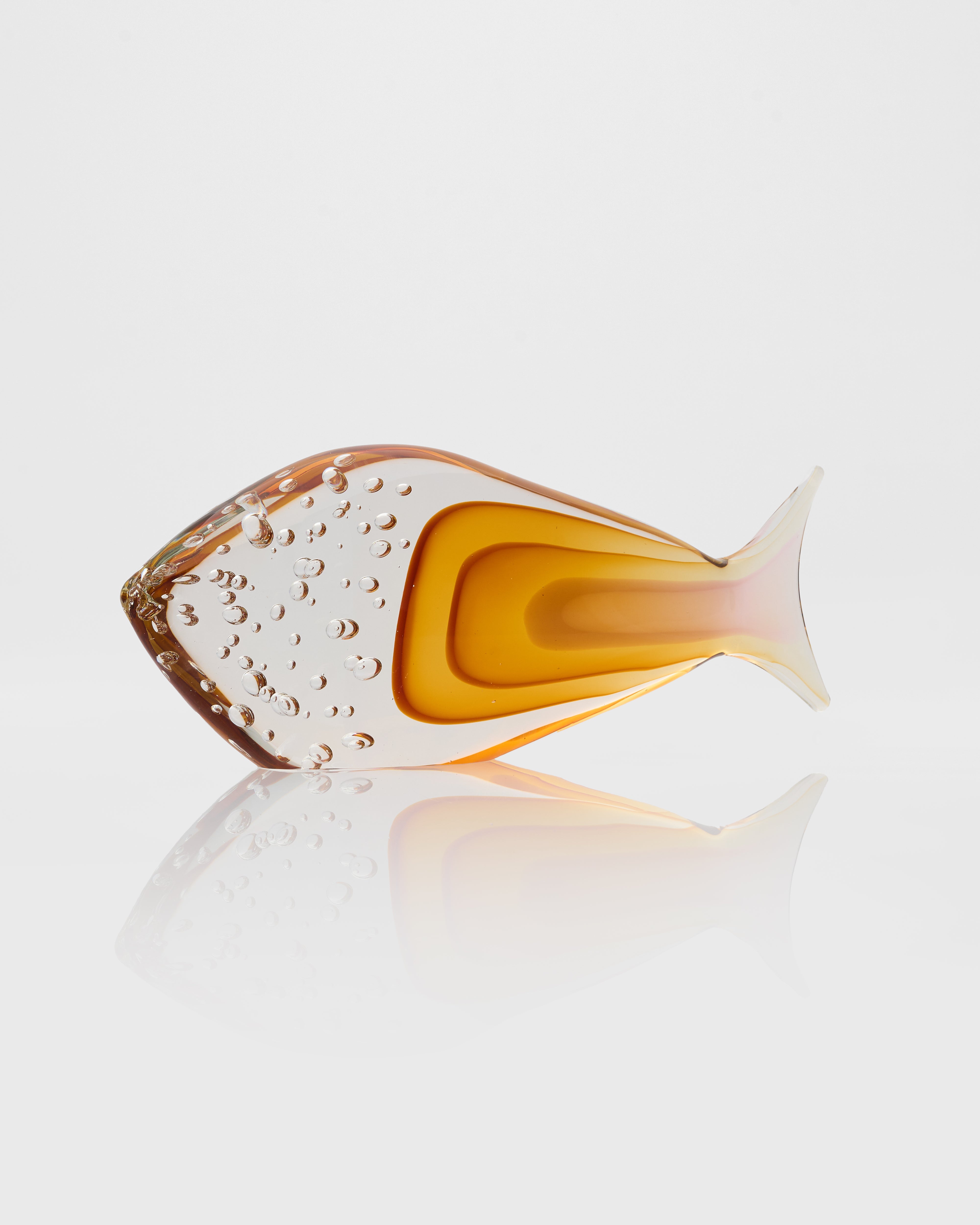 Glass fish-shaped object with gradient color on a white background