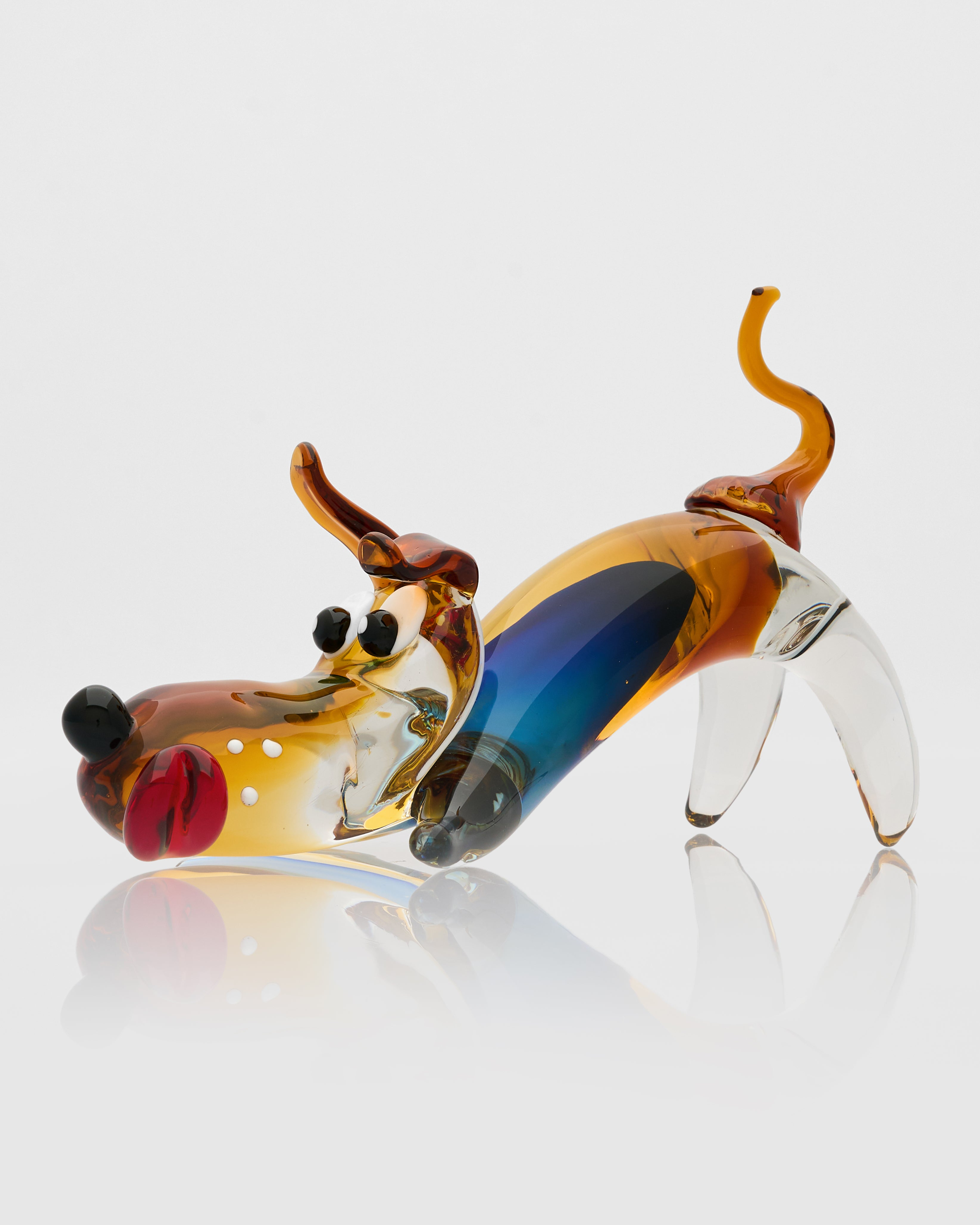 Glass dog sculpture with multicolored finish on a white background