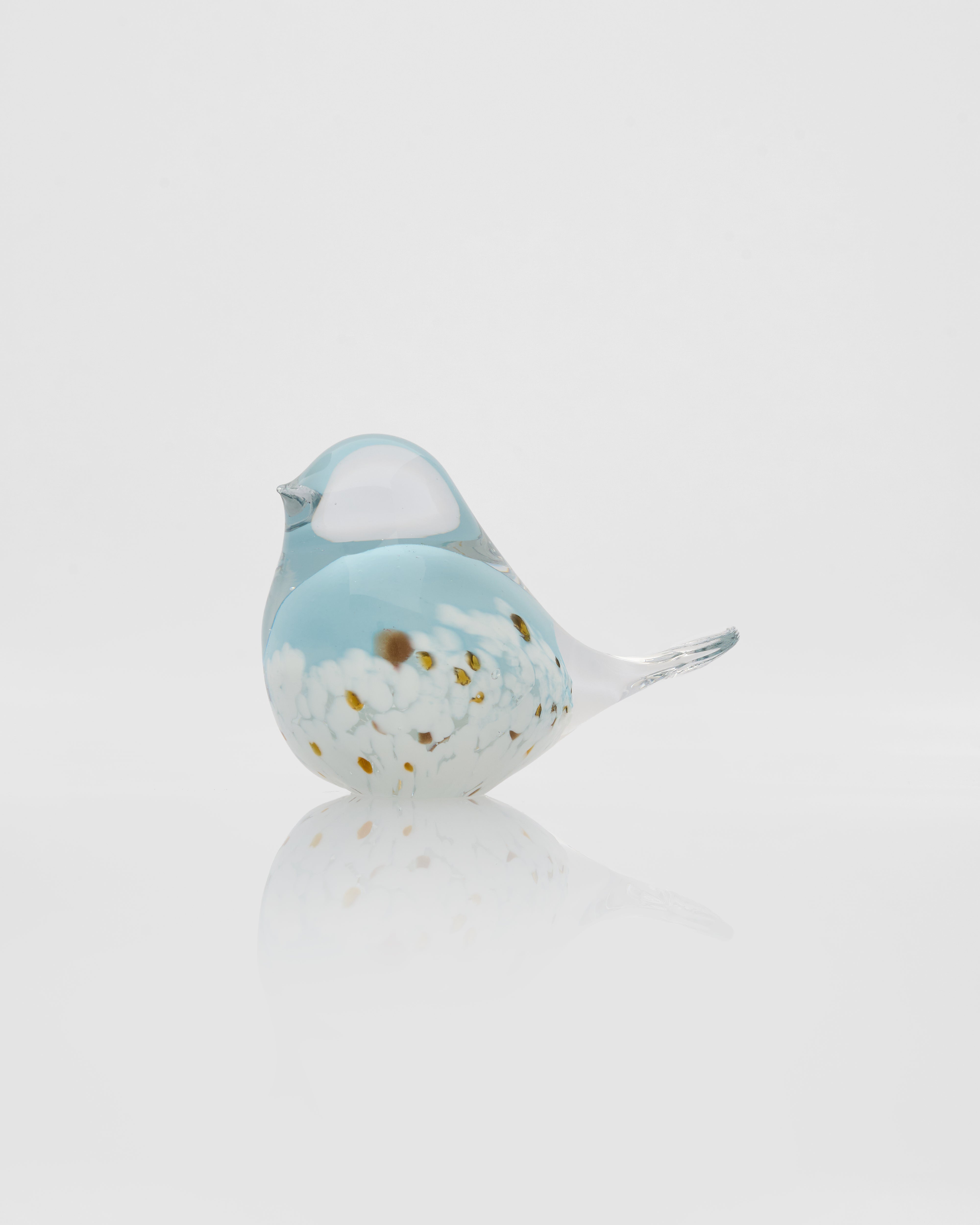 Glass bird figurine with a blue and white pattern on a light gray background