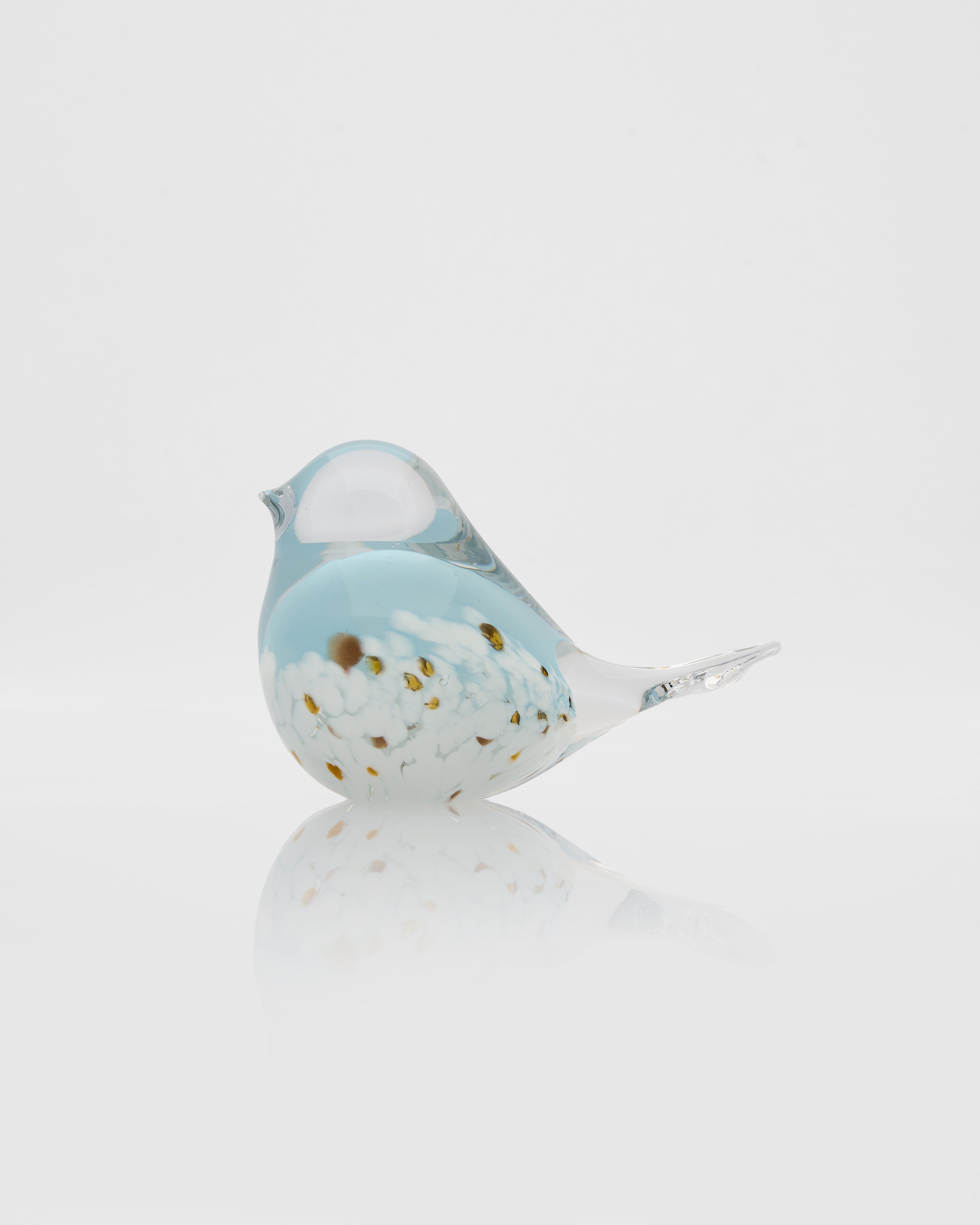Decorative glass bird with blue and white pattern on a light gray background