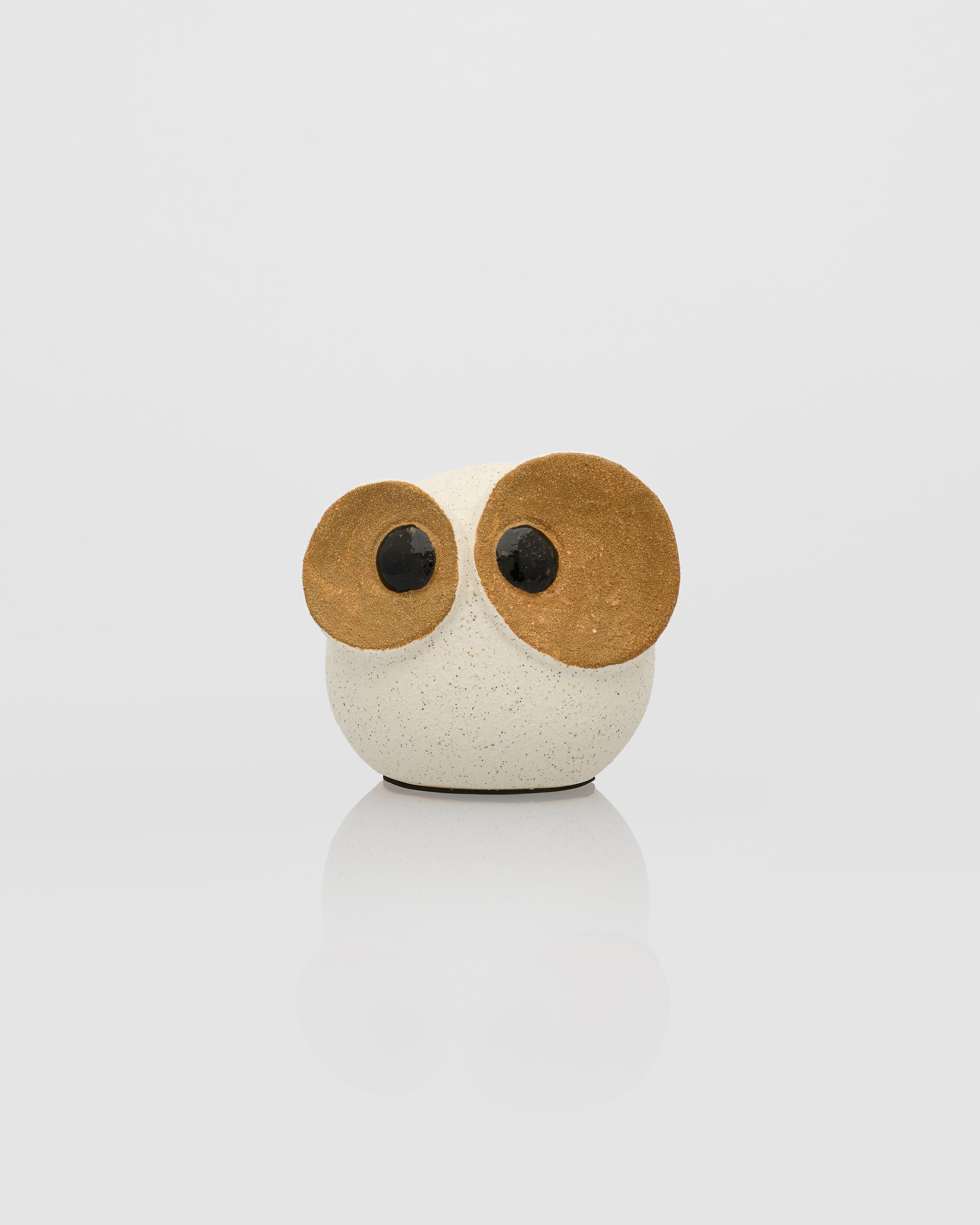 Small owl-shaped object with wooden ears on a white background