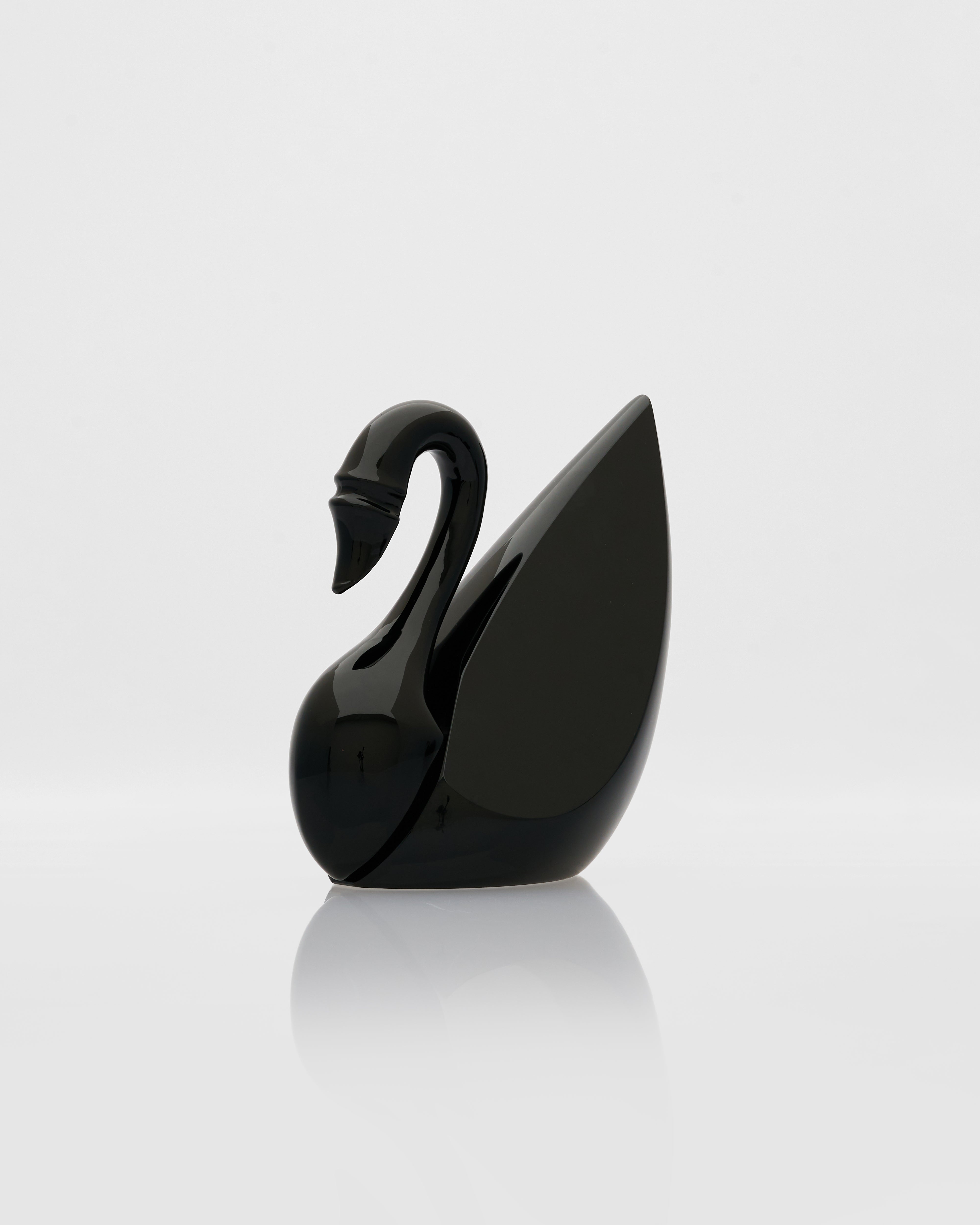 Black swan-shaped object on a light gray background