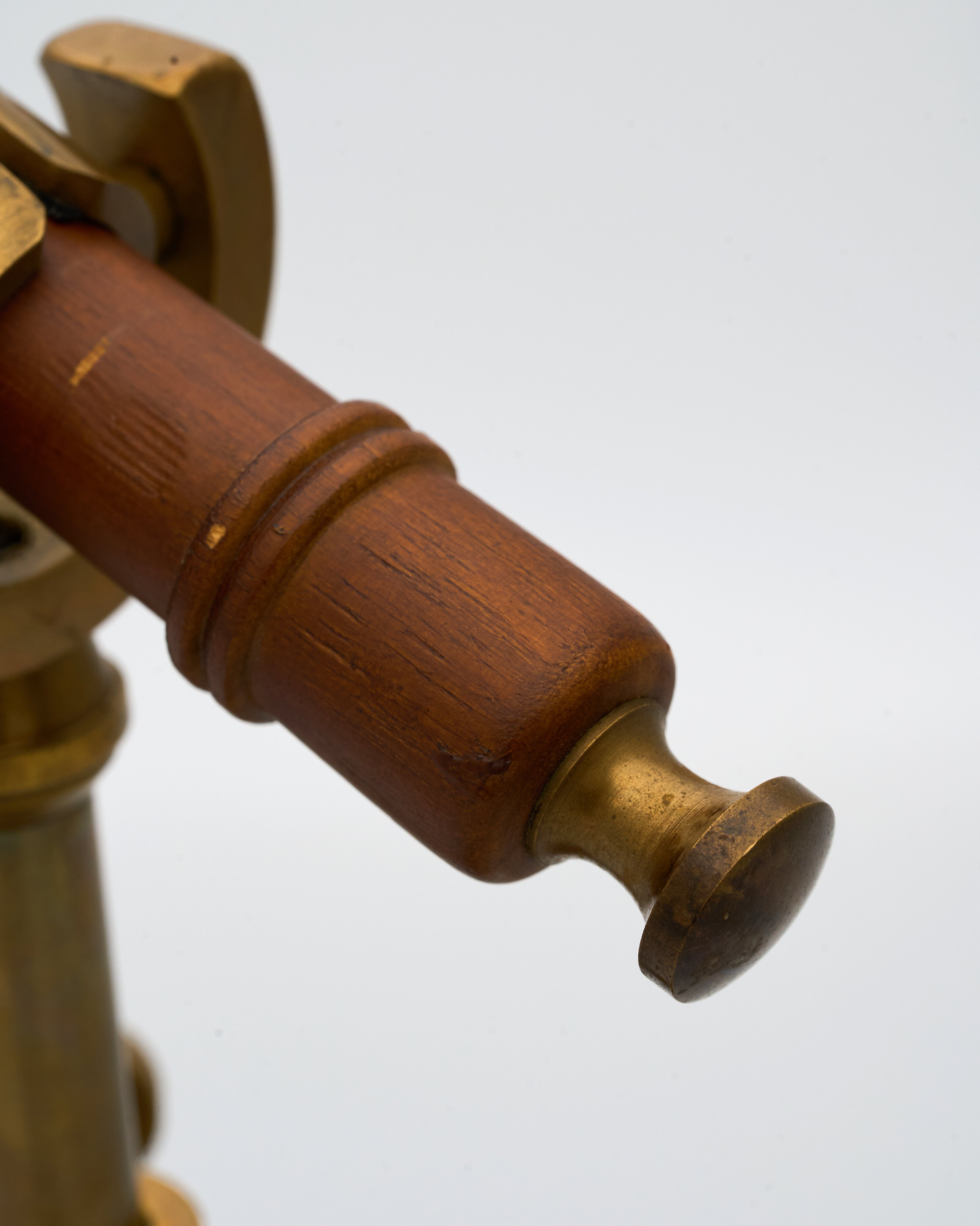 Close-up of a wooden and brass telescope on a white background