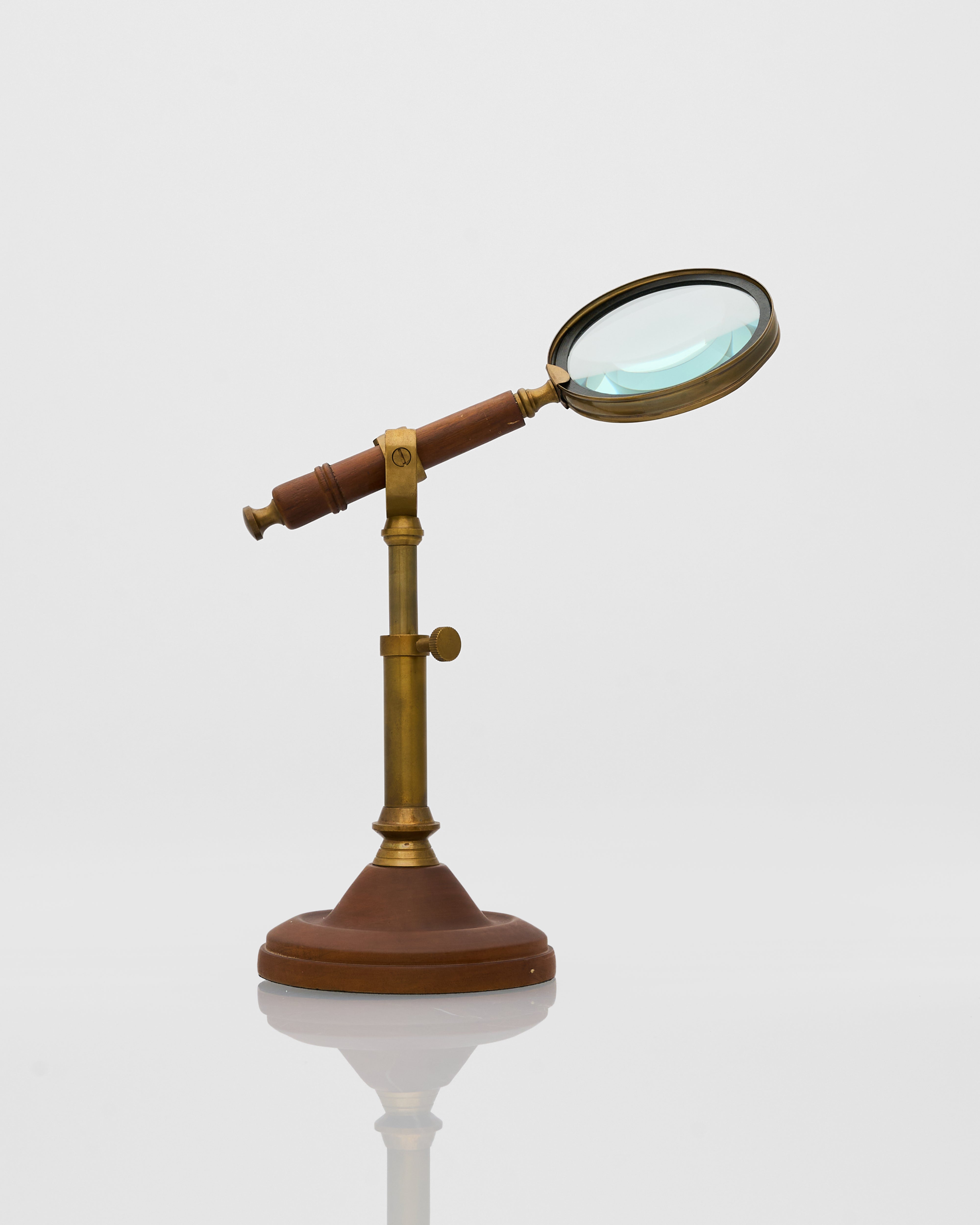 Vintage-style magnifying glass on a stand with a white background