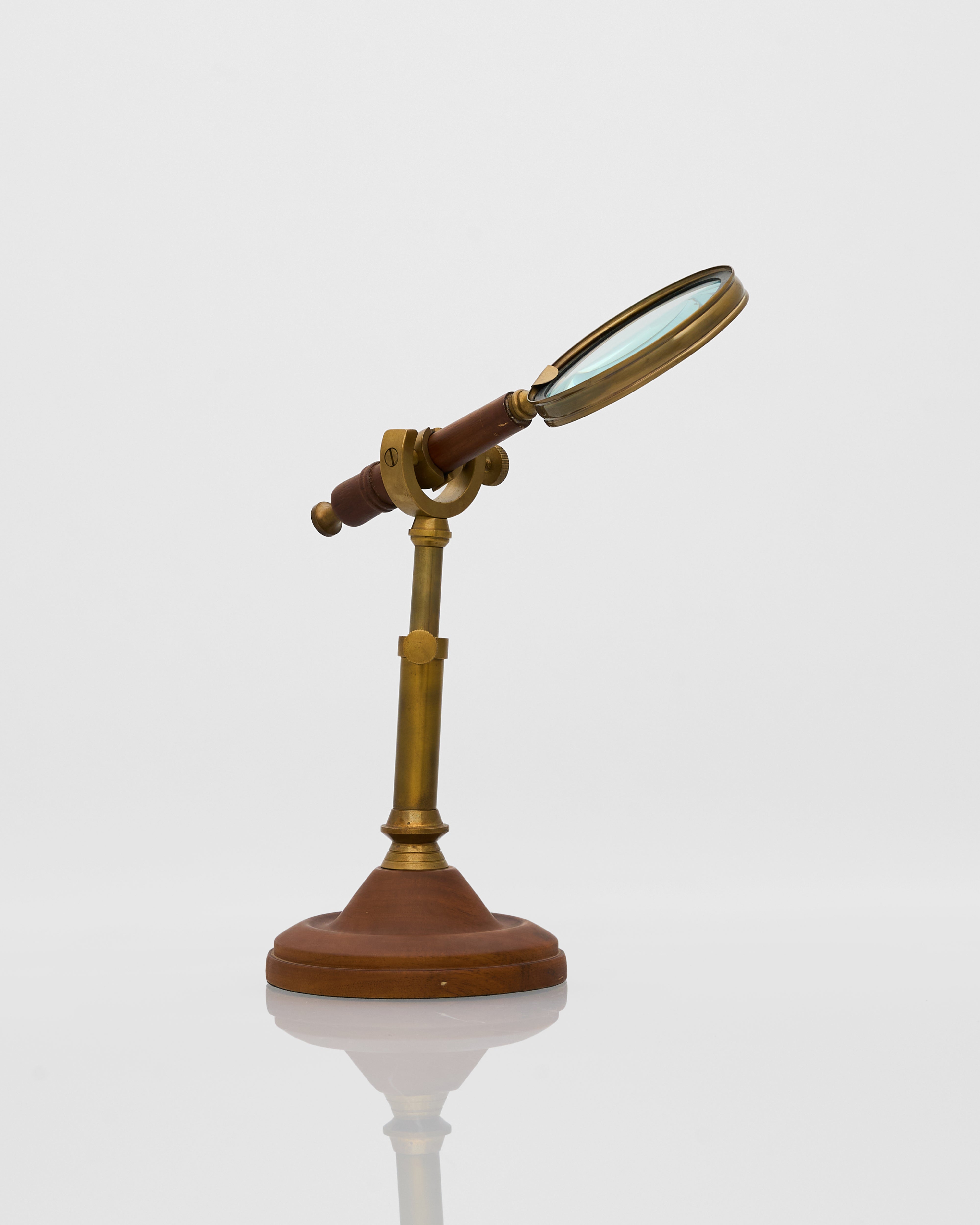 Vintage-style magnifying glass on a stand with a white background