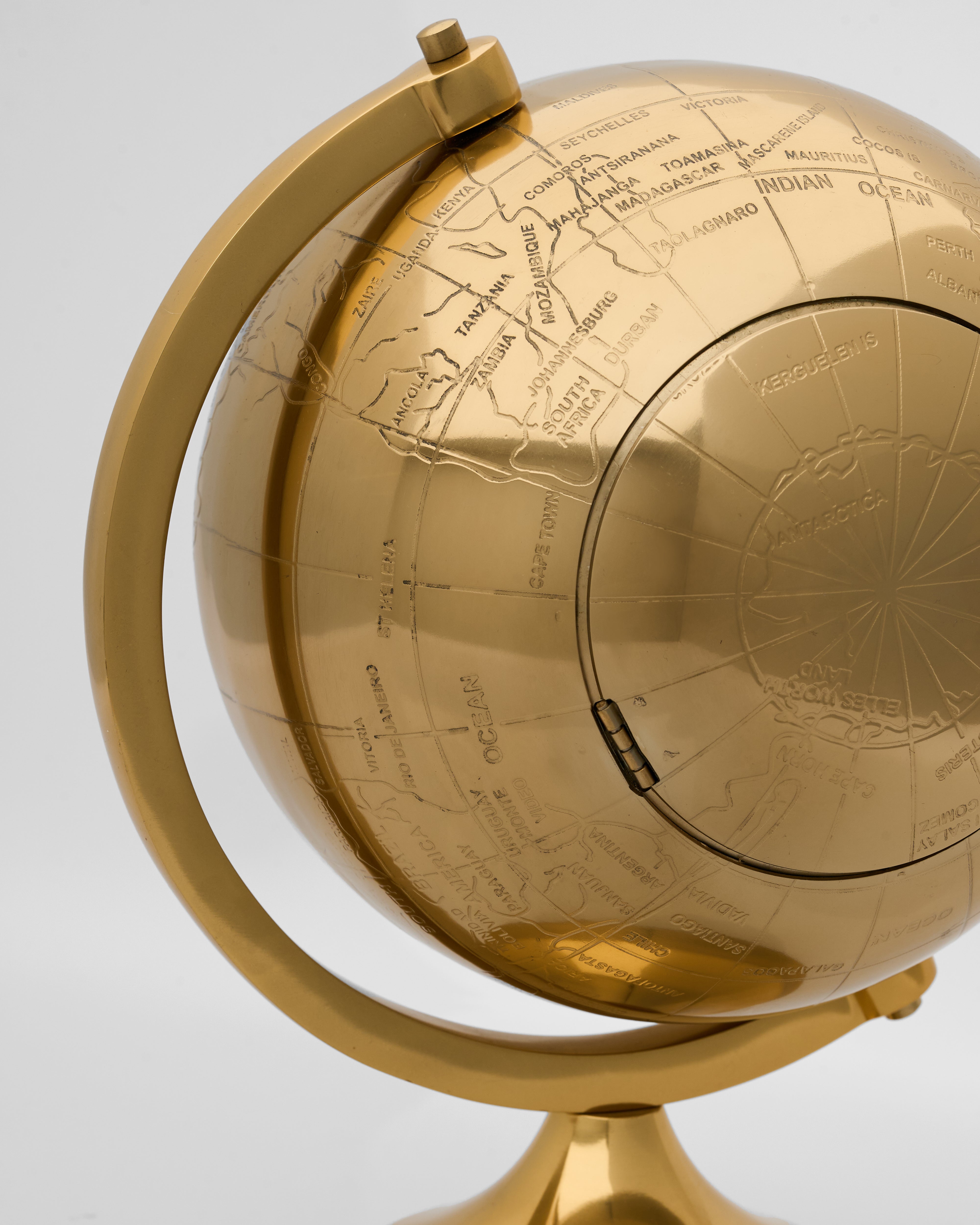 Close-up of vintage globe inspired table clock highlighting precision detailing and classic antique appeal