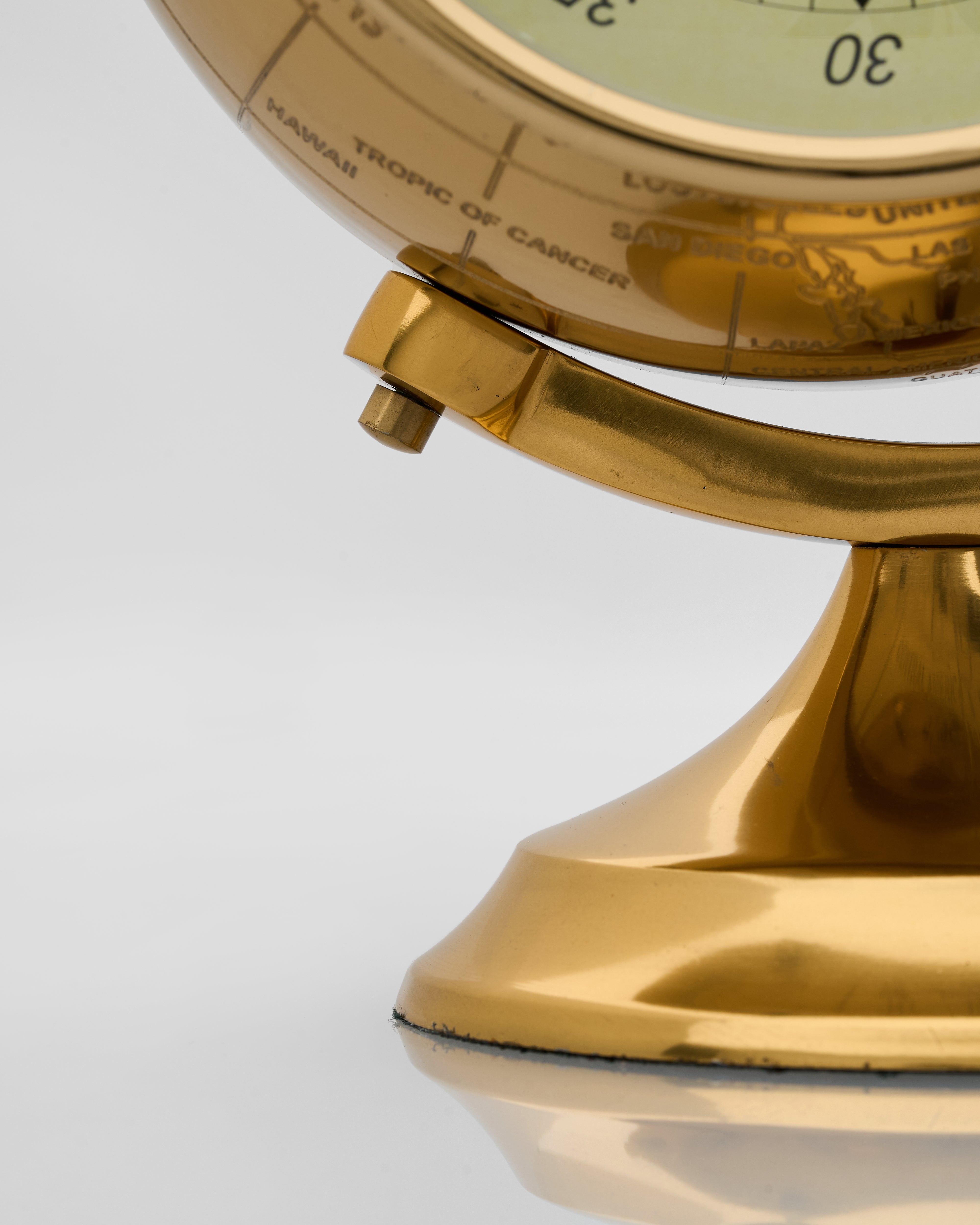Detailed view of vintage globe inspired table clock emphasizing intricate map detailing and refined luxury finish