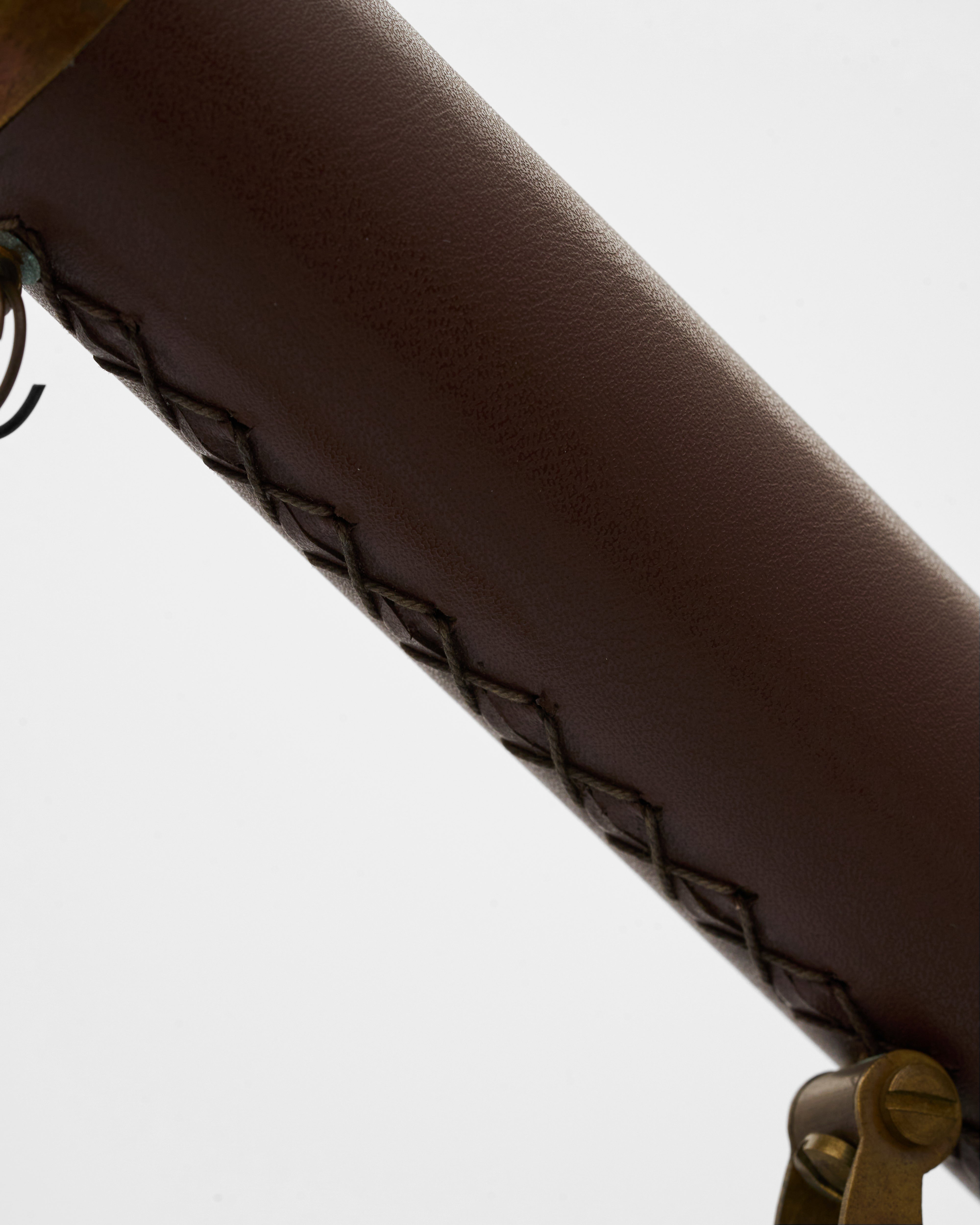 Close-up of a brown leather handle of telescope with geometric pattern on a white background