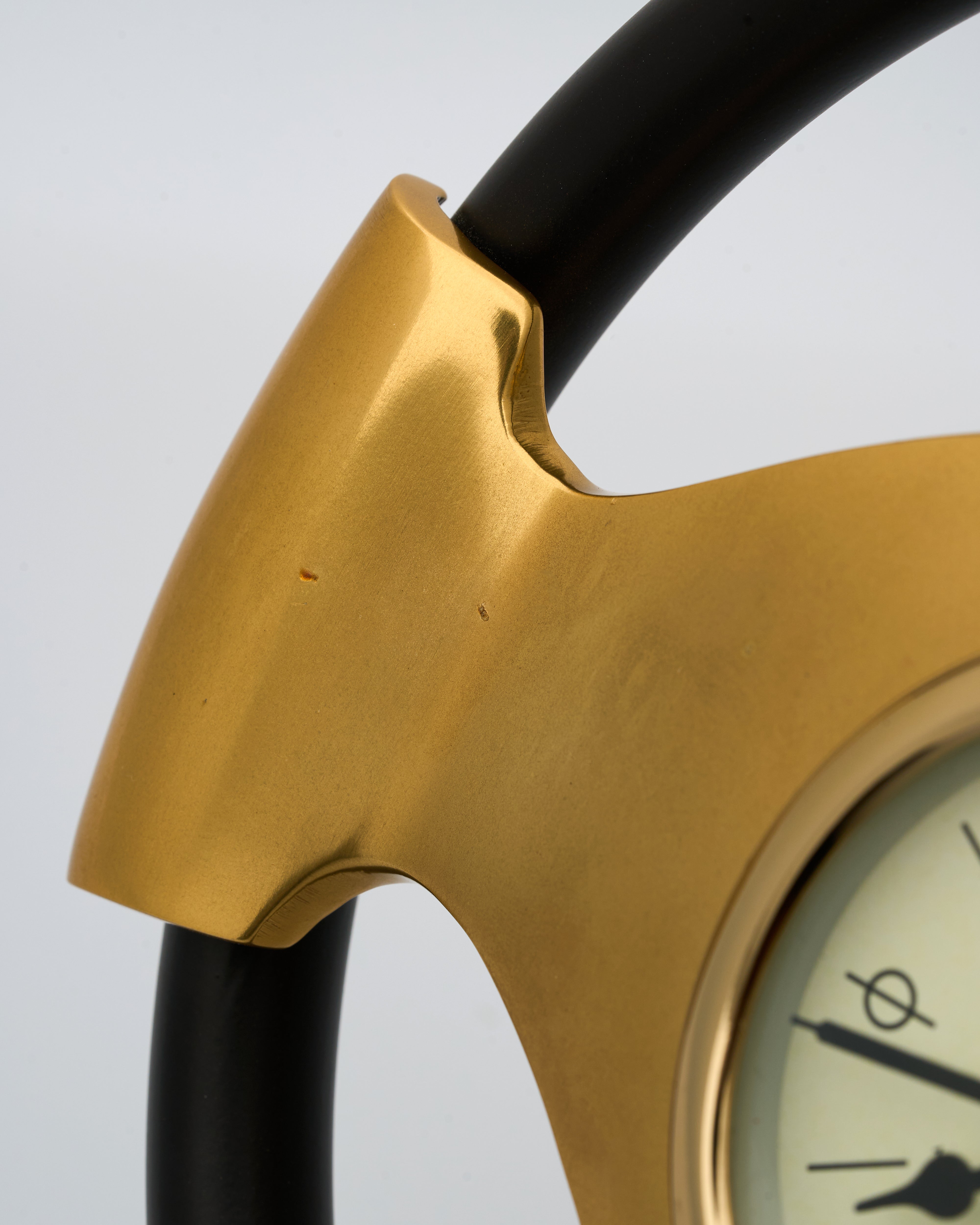 Close-up of a gold clock with black hands on a light gray background