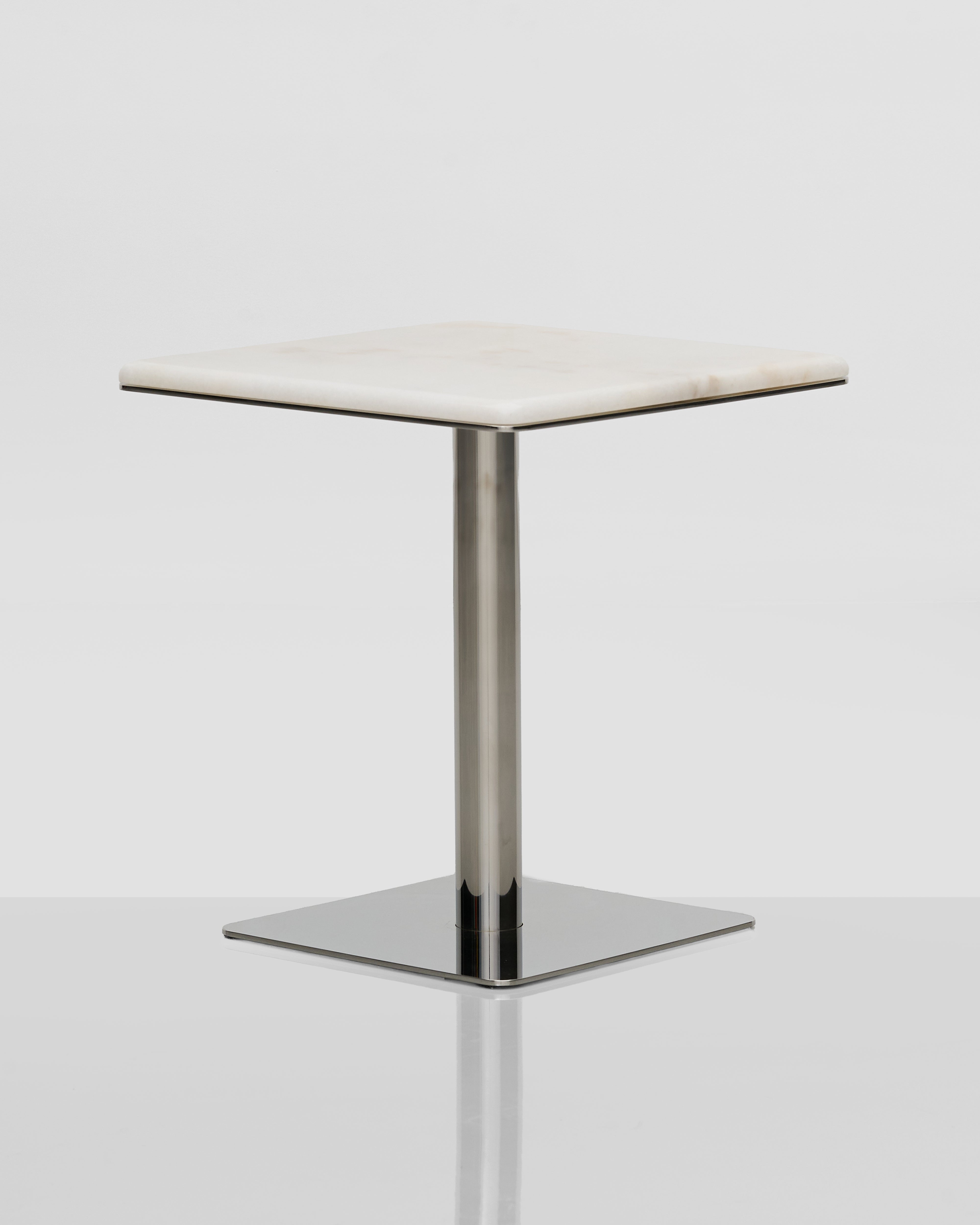 Small square table with a white marble top and metal base on a light gray background