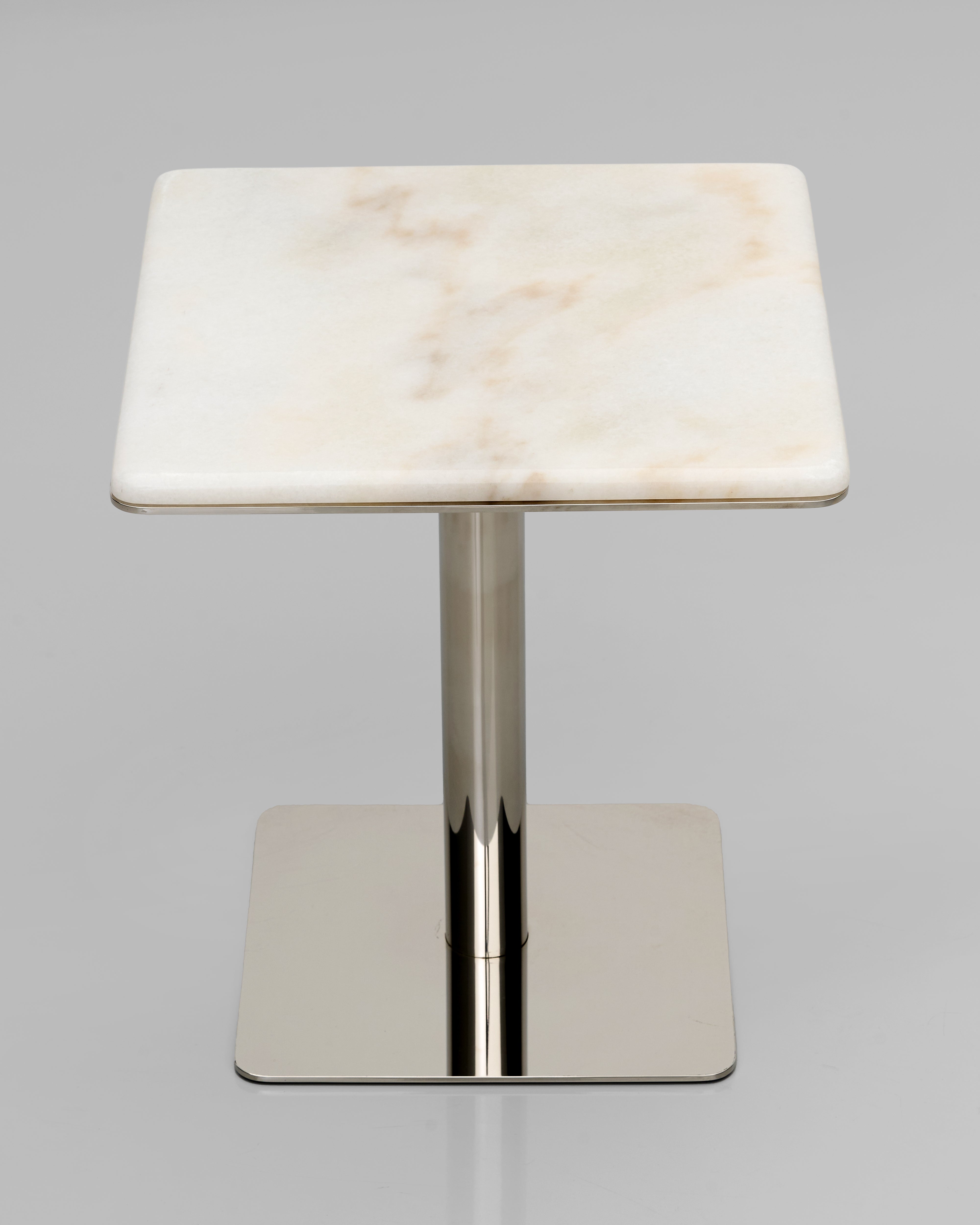Small table with marble top and metal base on a gray background
