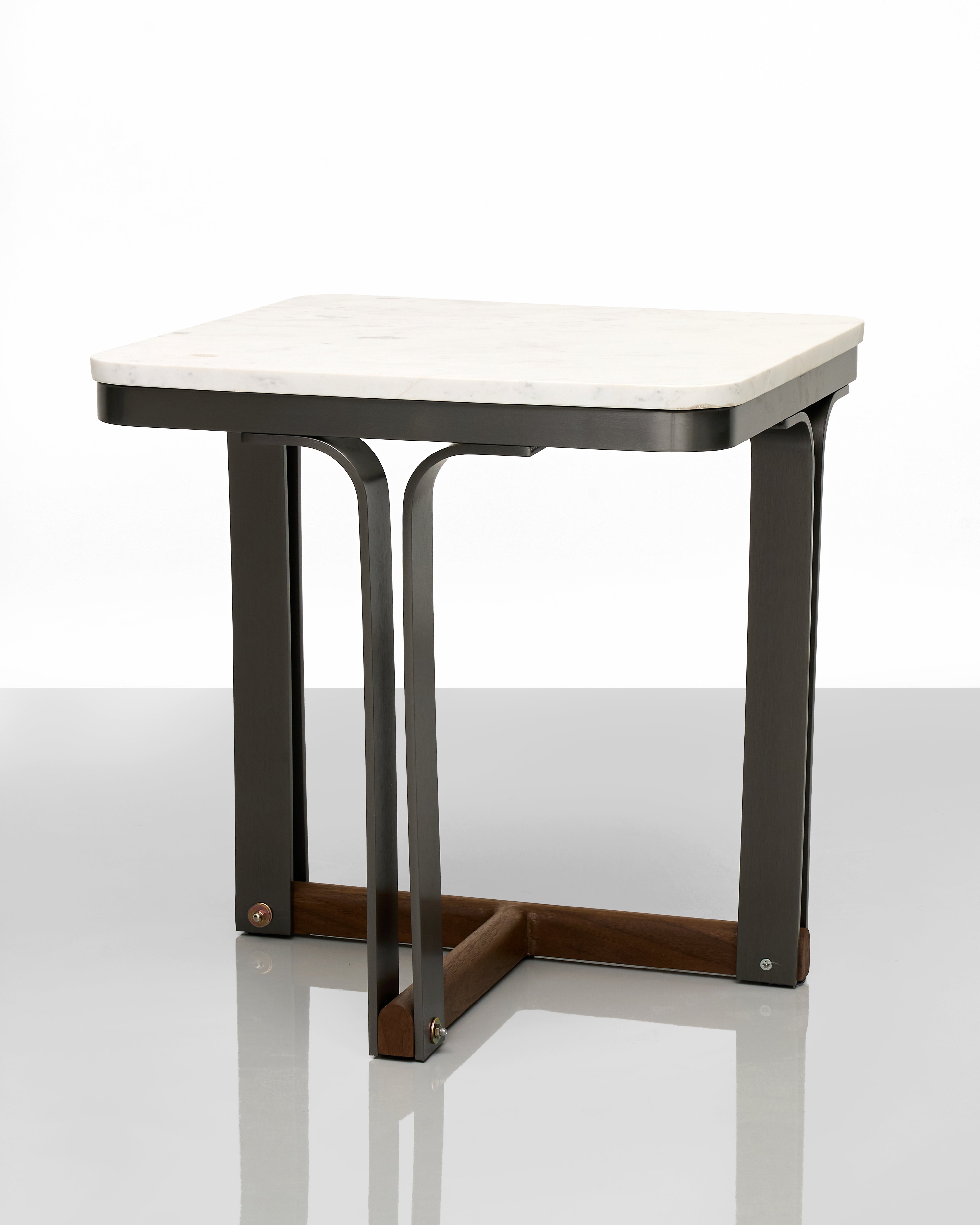 Small table with white top and black metal legs on a reflective surface