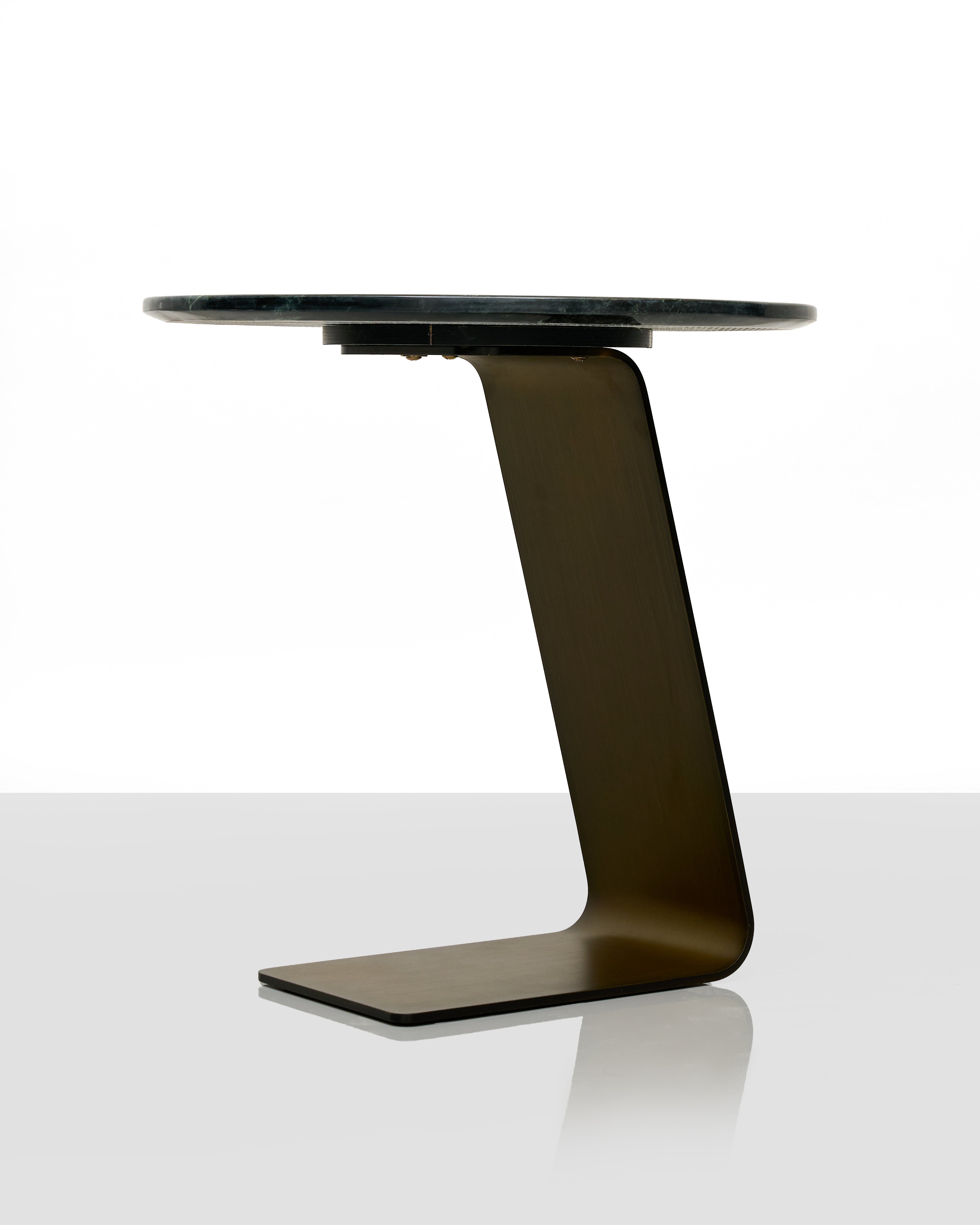 Modern side table with a black glass top and unique metal base on a white background