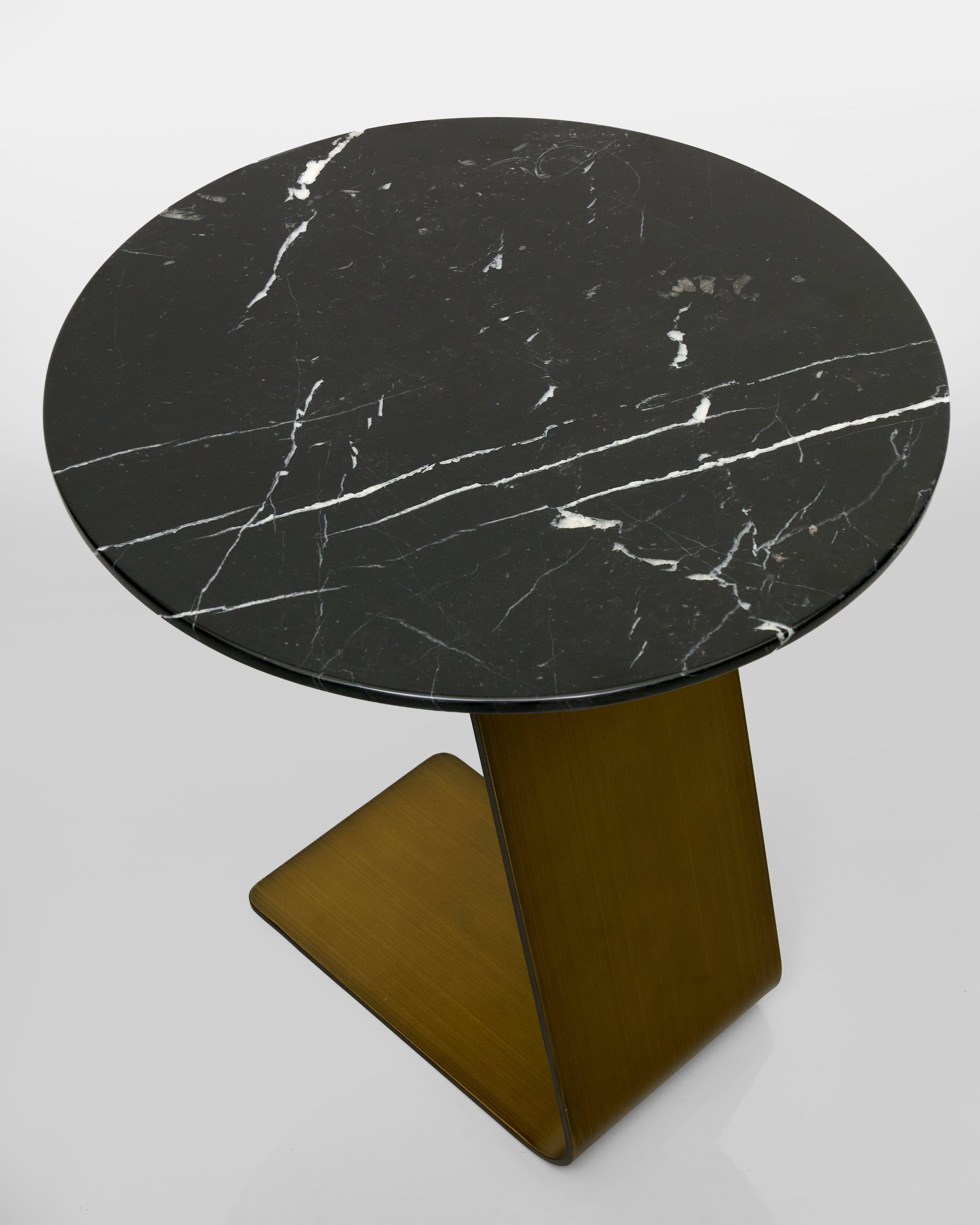 Round black marble table with a brown base on a white background