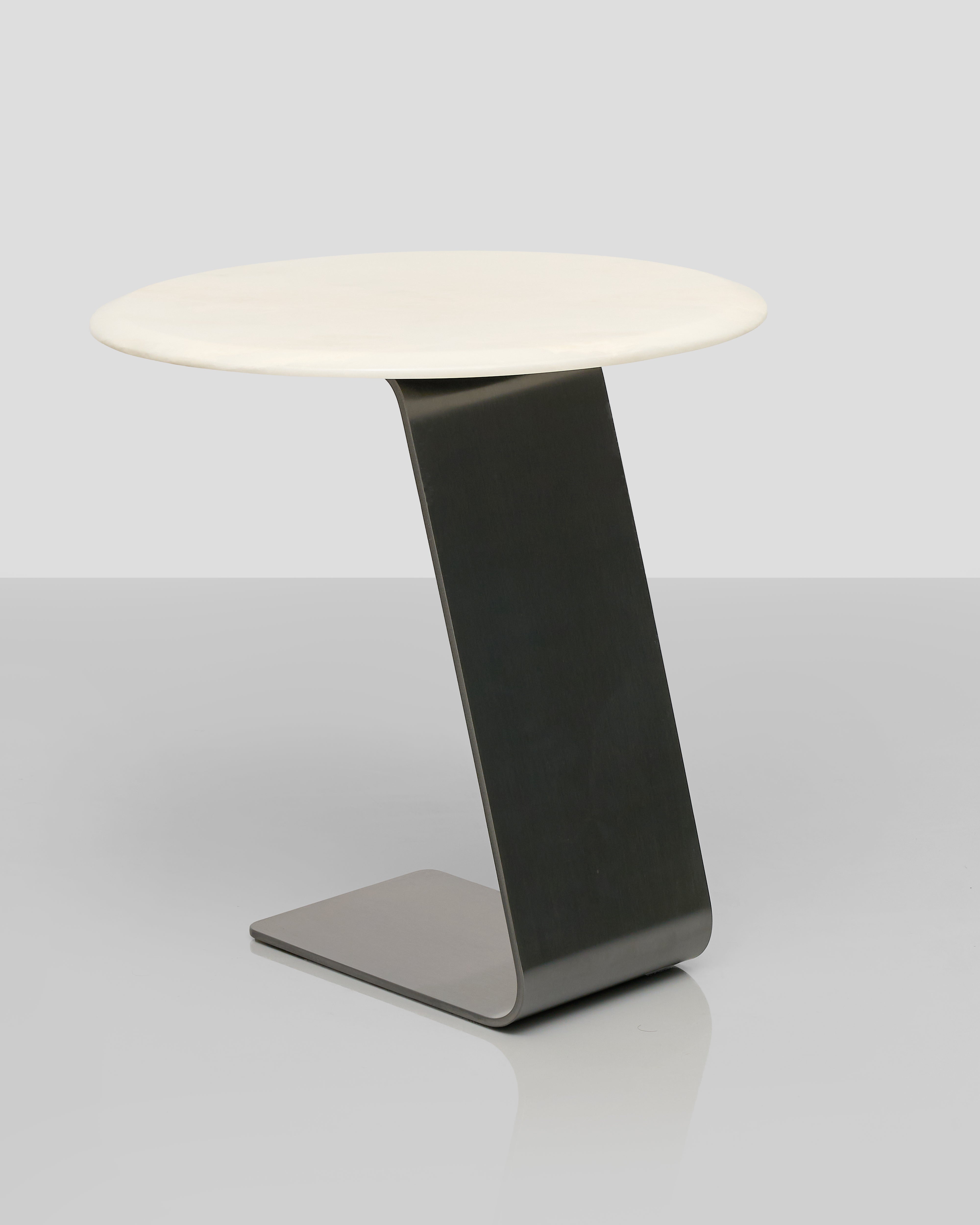 Modern side table with a white round top and black curved base on a light gray background