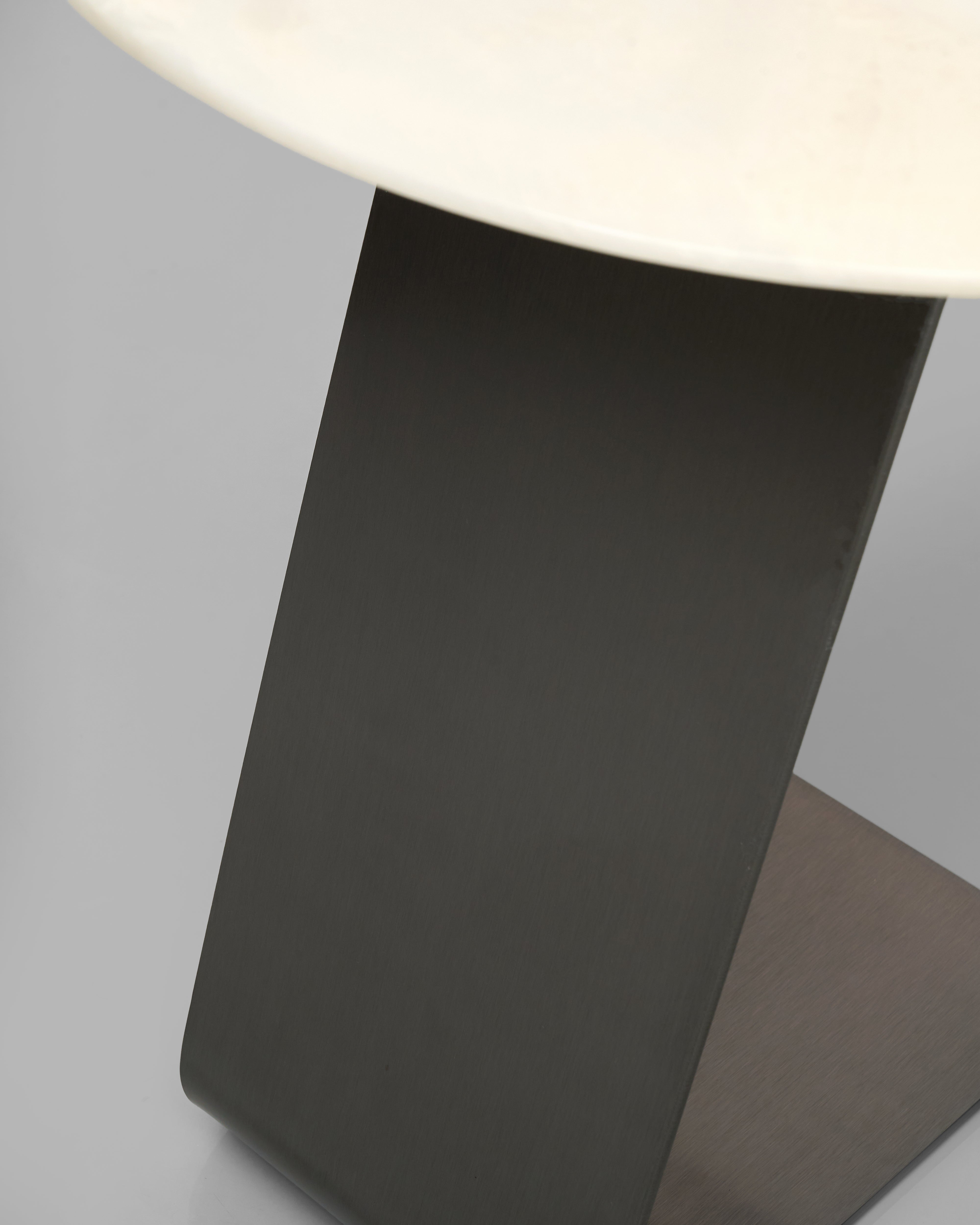 Close-up of a modern side table with a white top and black base.