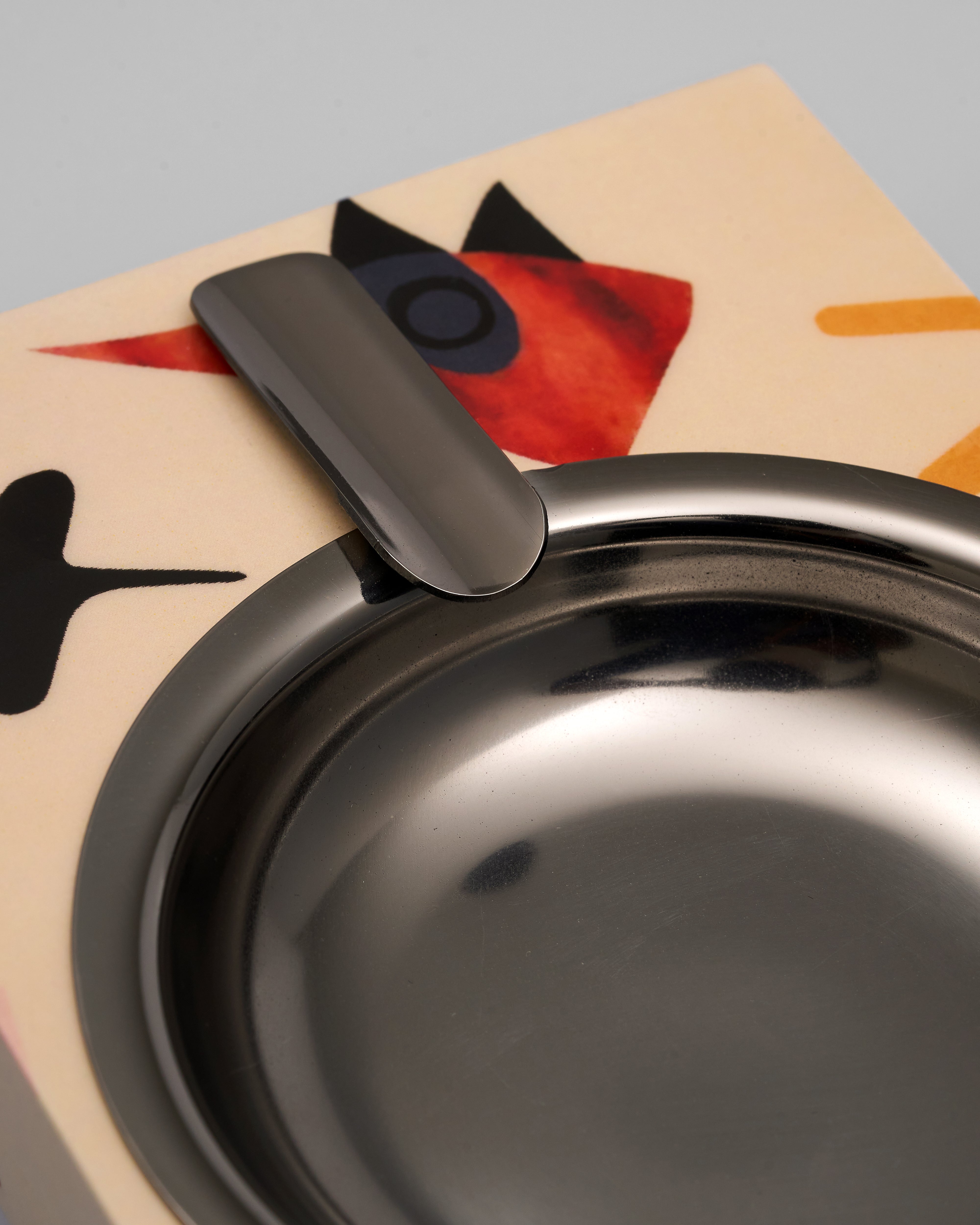 Metallic bowl with a lid on a colorful abstract background