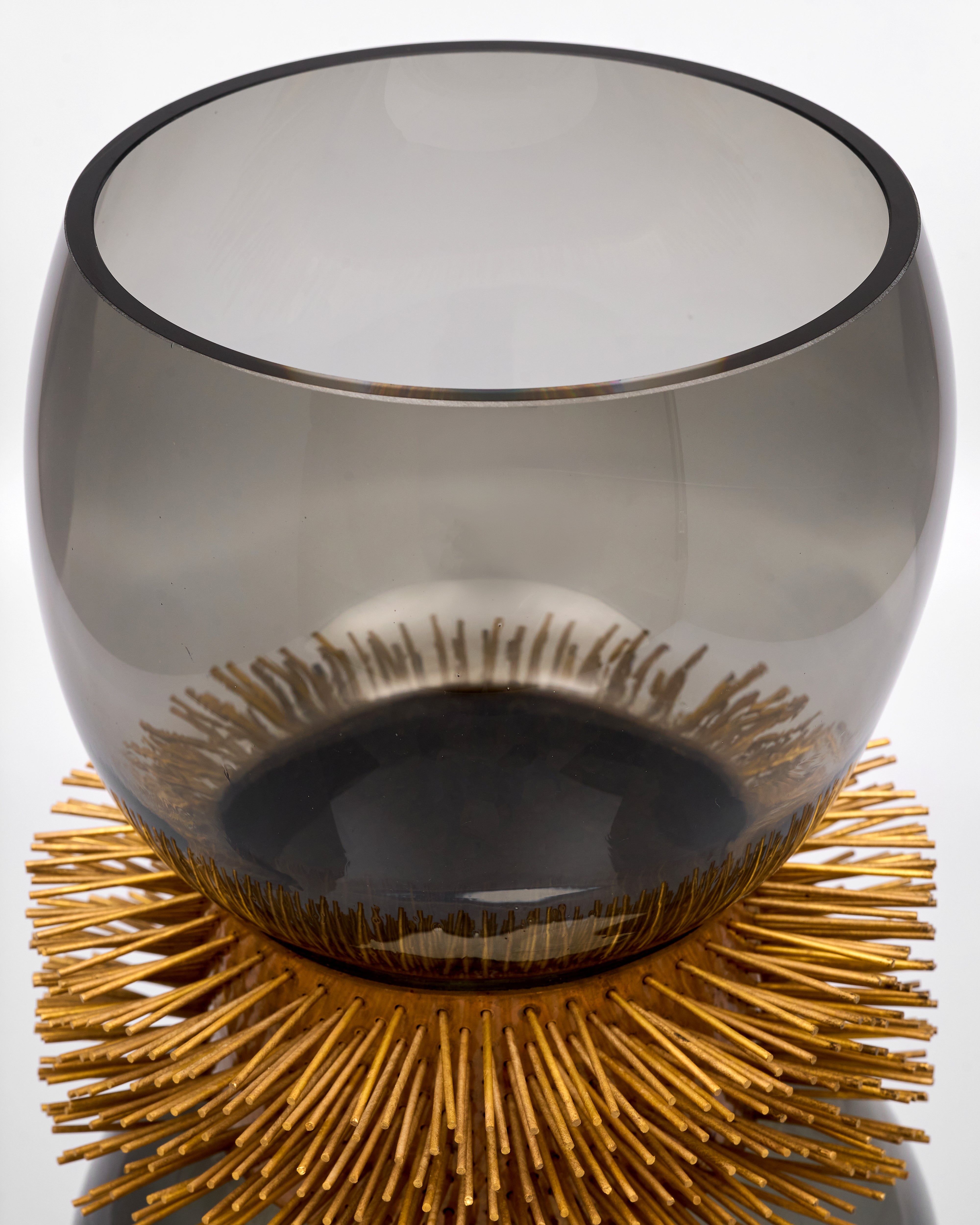 Decorative glass bowl with gold base on a white background