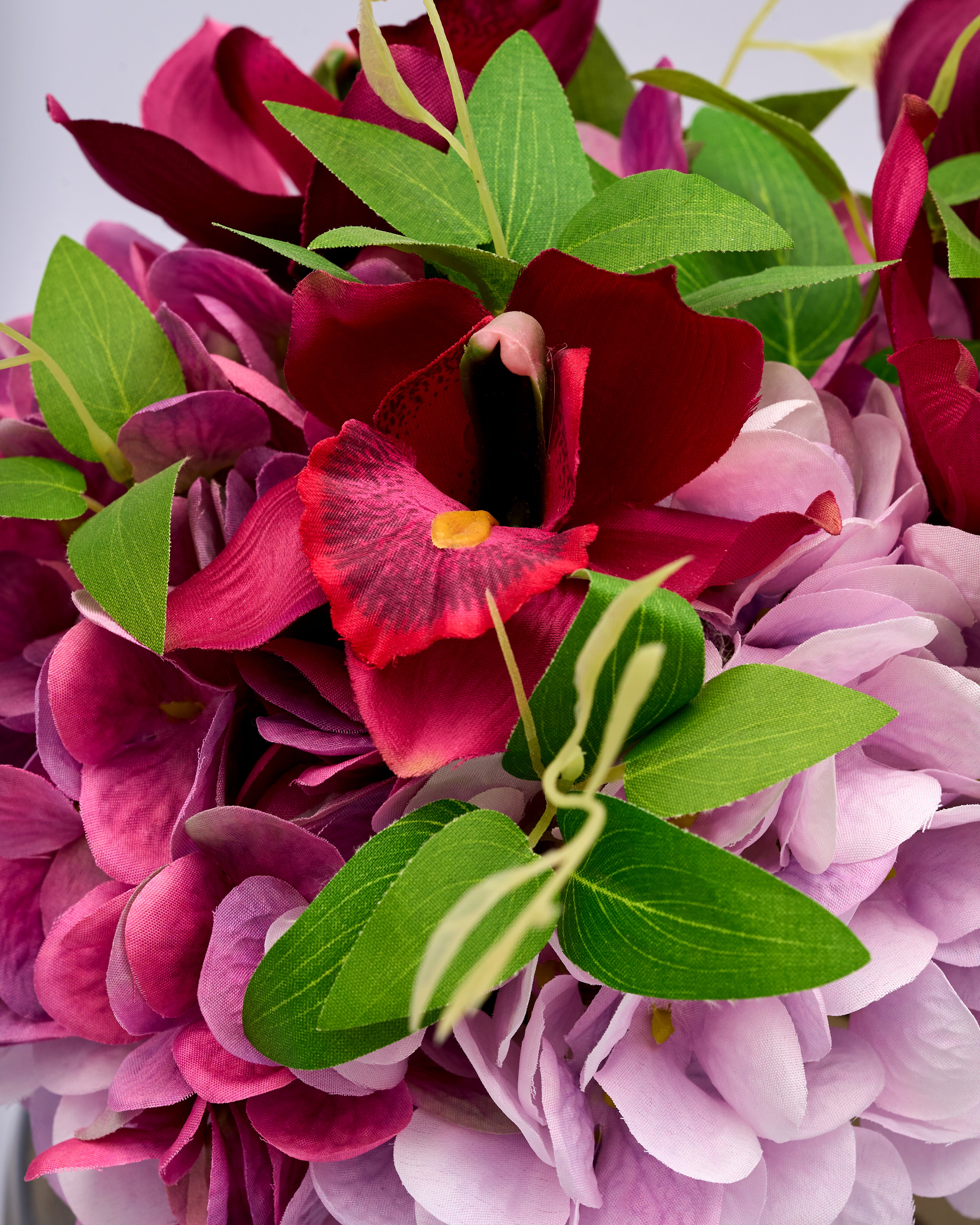 Close-up of a bouquet with pink, red, and green flowers.
