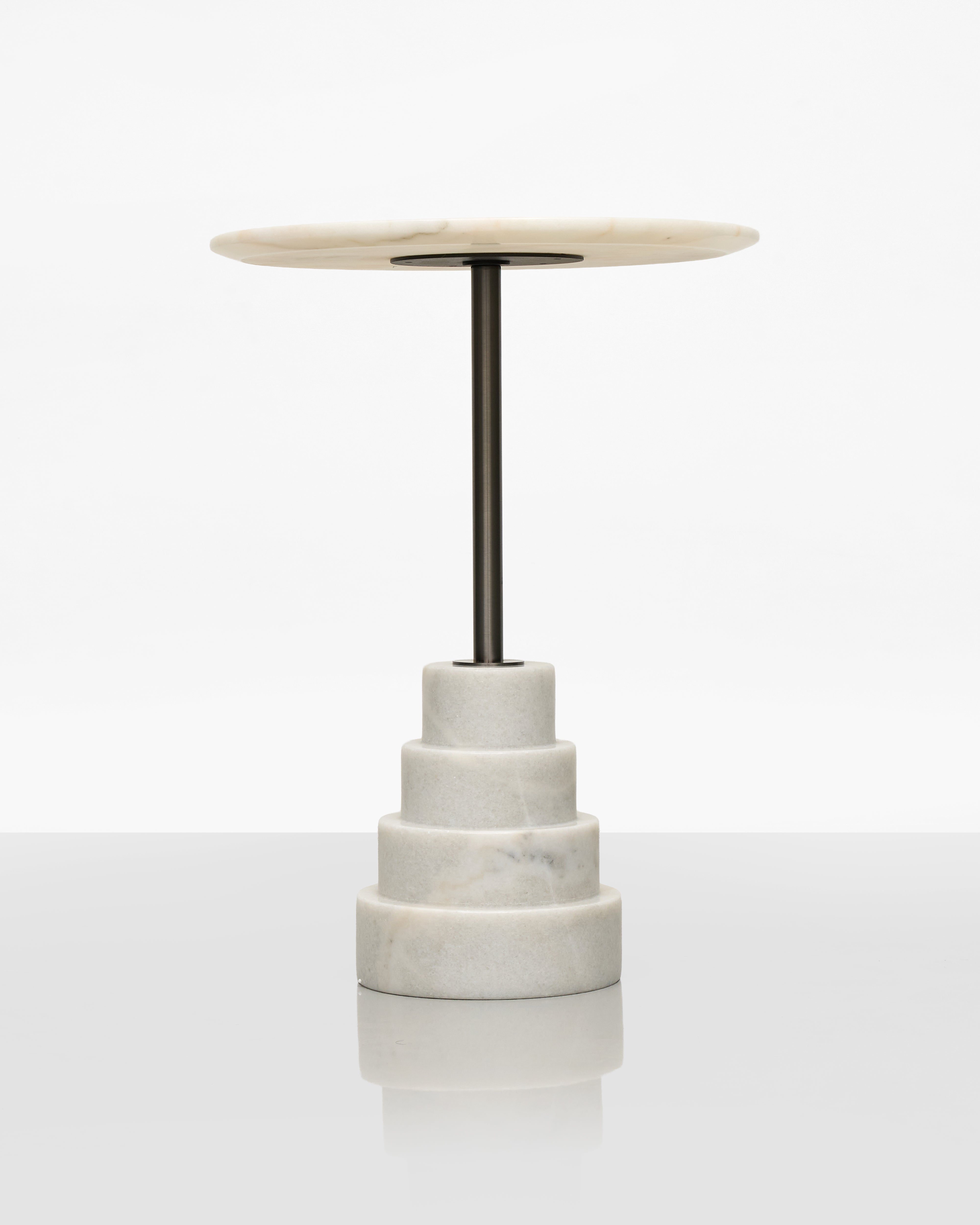 Small round marble top side table with a metal base on a white background