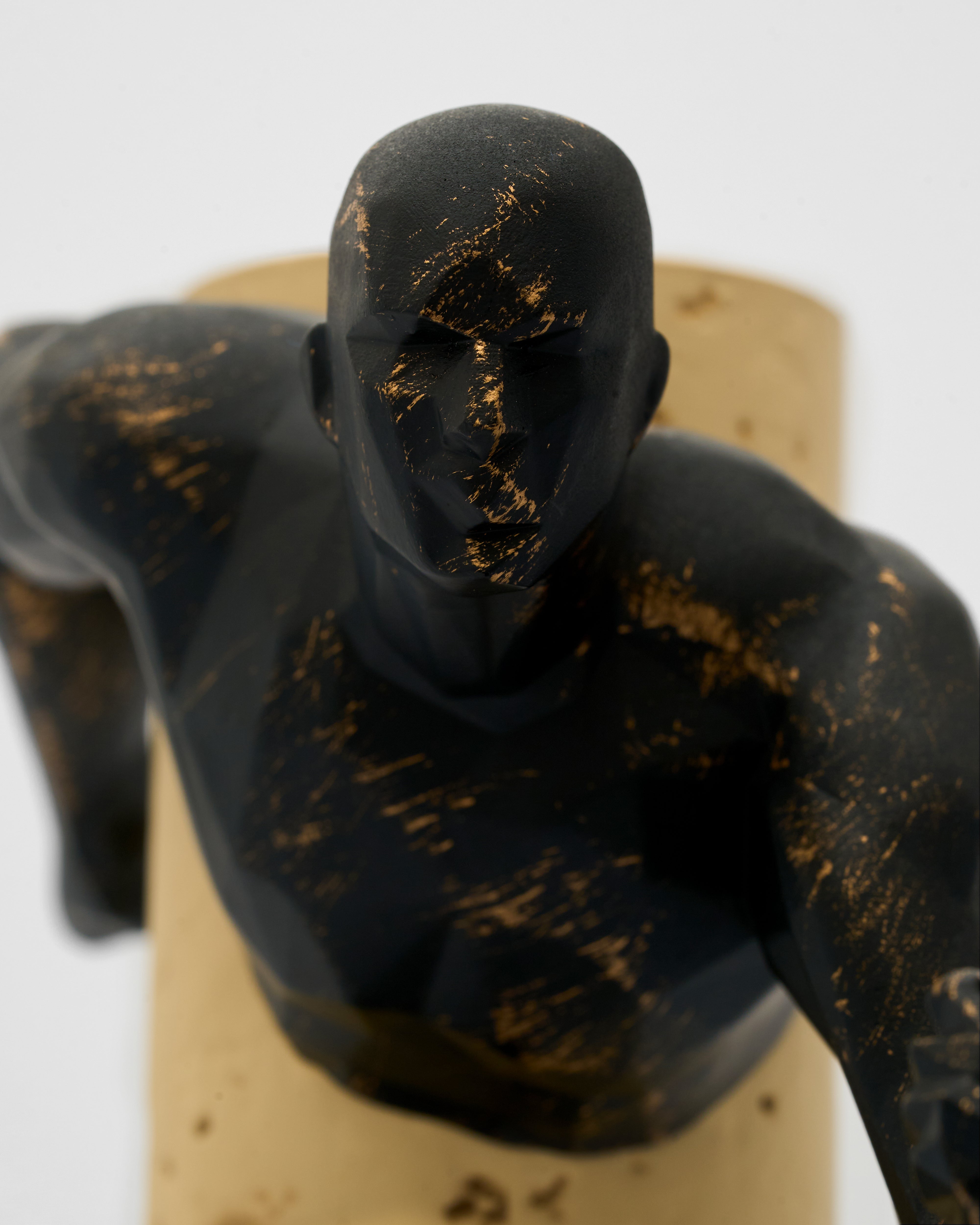 Black and gold abstract sculpture on a white background