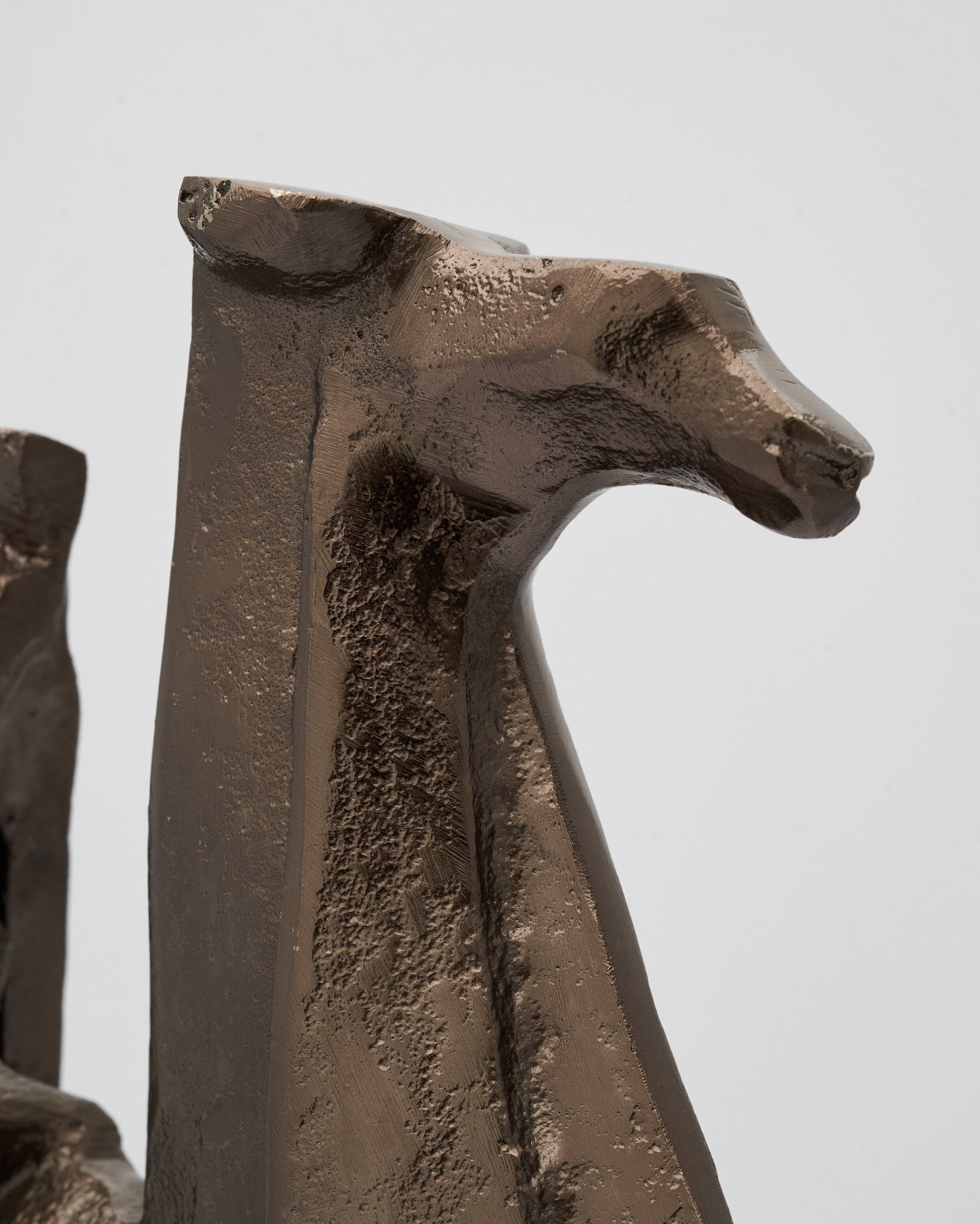Bronze sculpture of a camel sculpture with a prominent head on a plain background