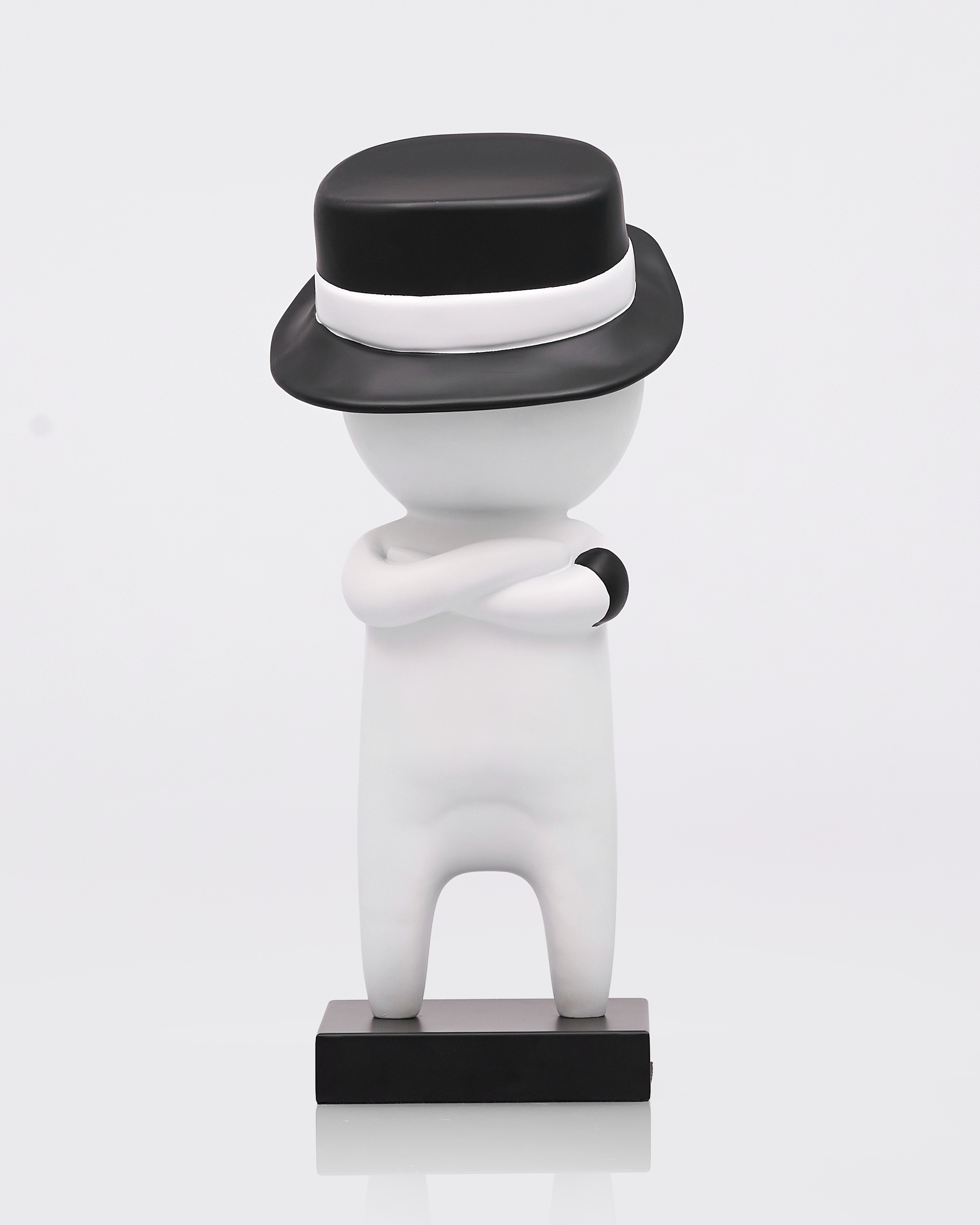 White figurine with a black hat on a white background