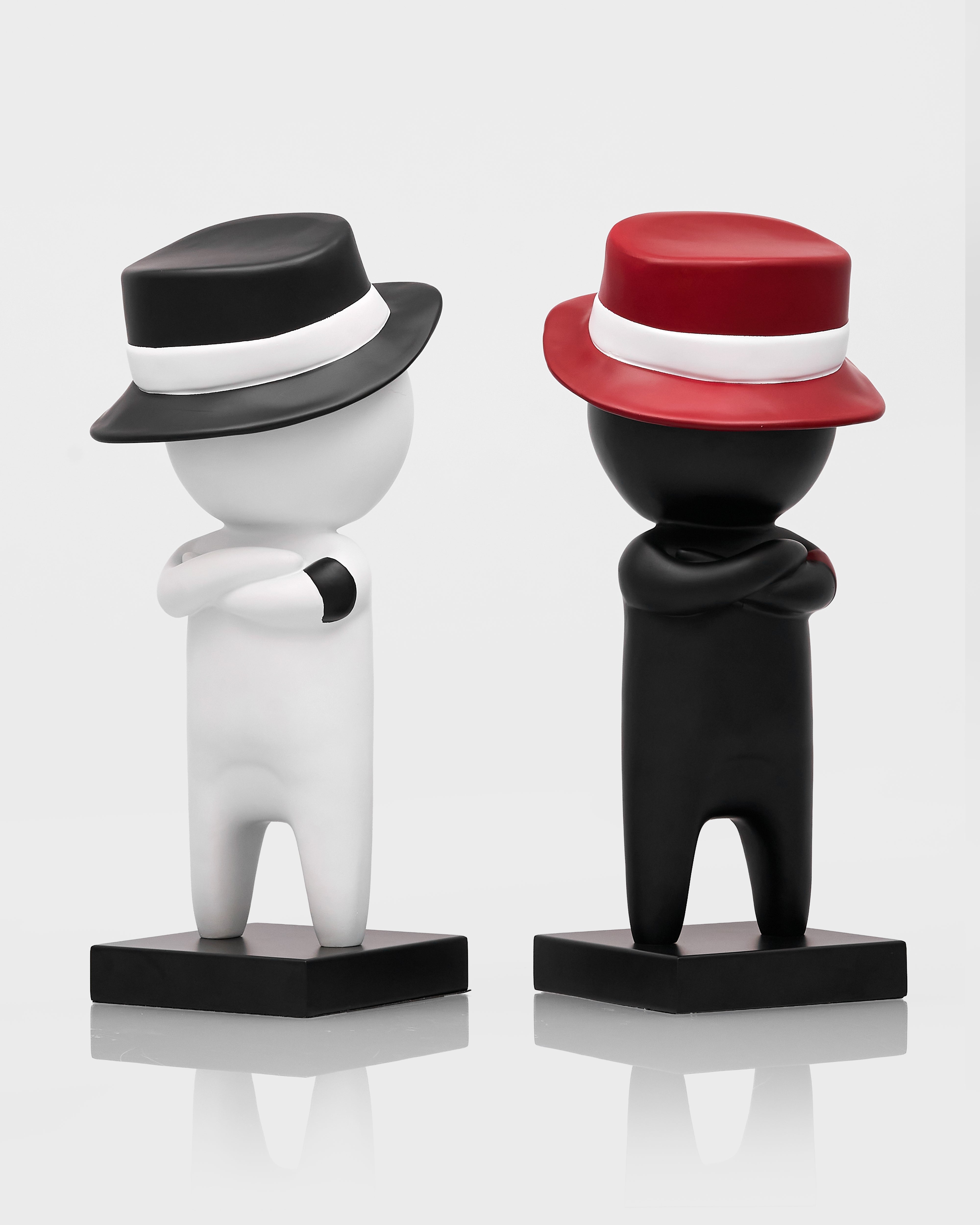 Two decorative figures with hats on a white background