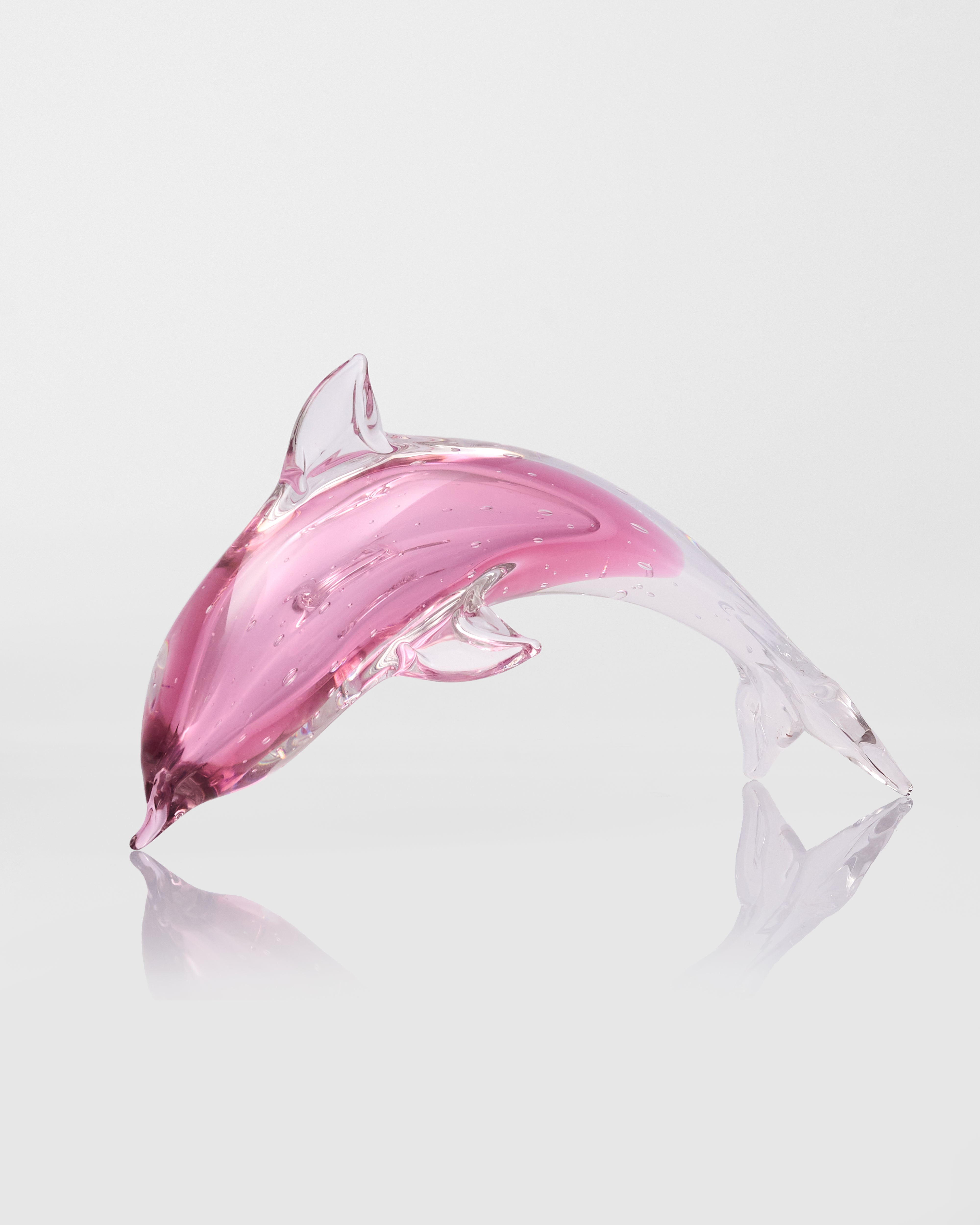 Pink glass dolphin on a white background