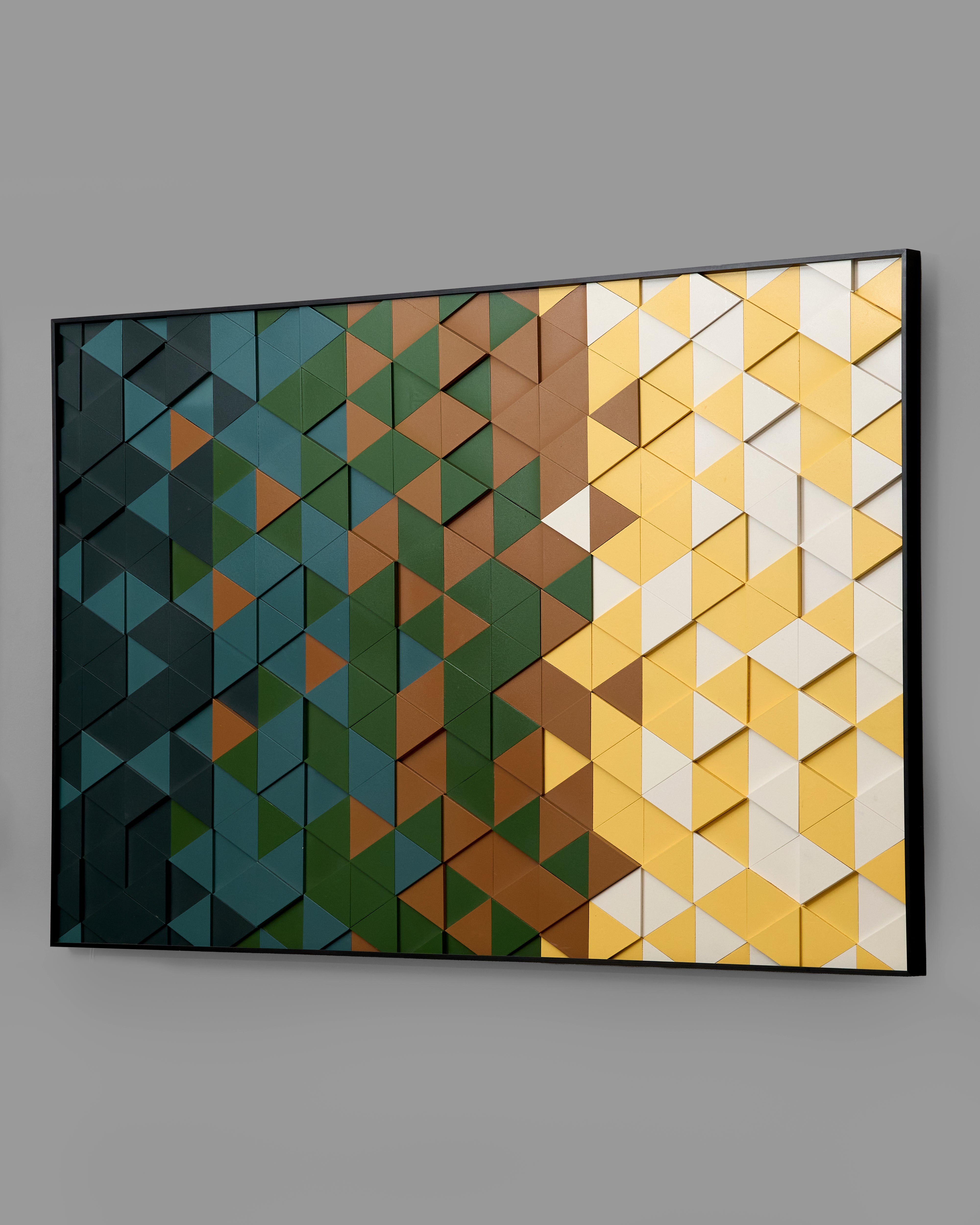 Geometric wall art with triangular patterns in blue, green, brown, and yellow on a gray background