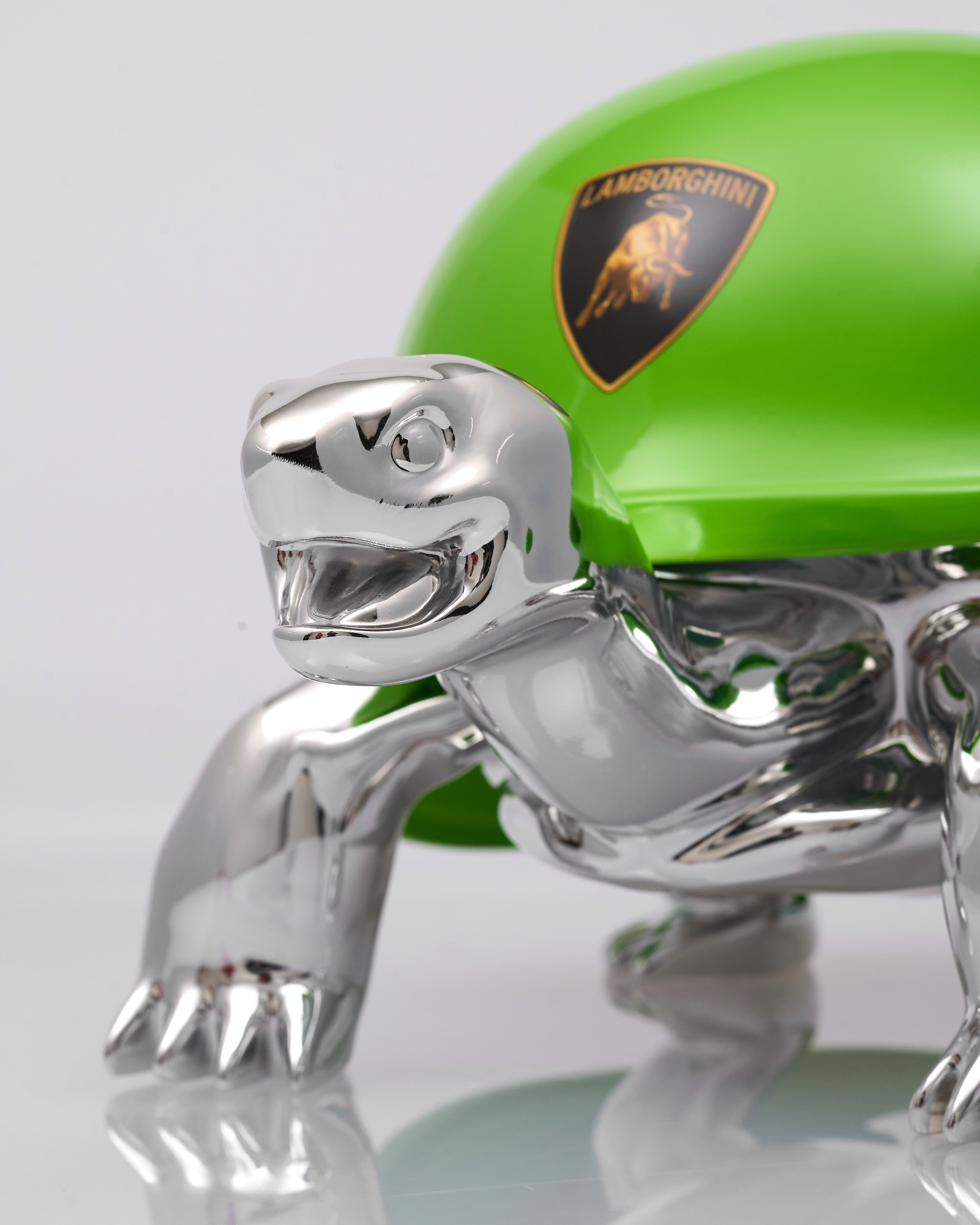 Chrome dinosaur figurine with a green object featuring a logo in the background