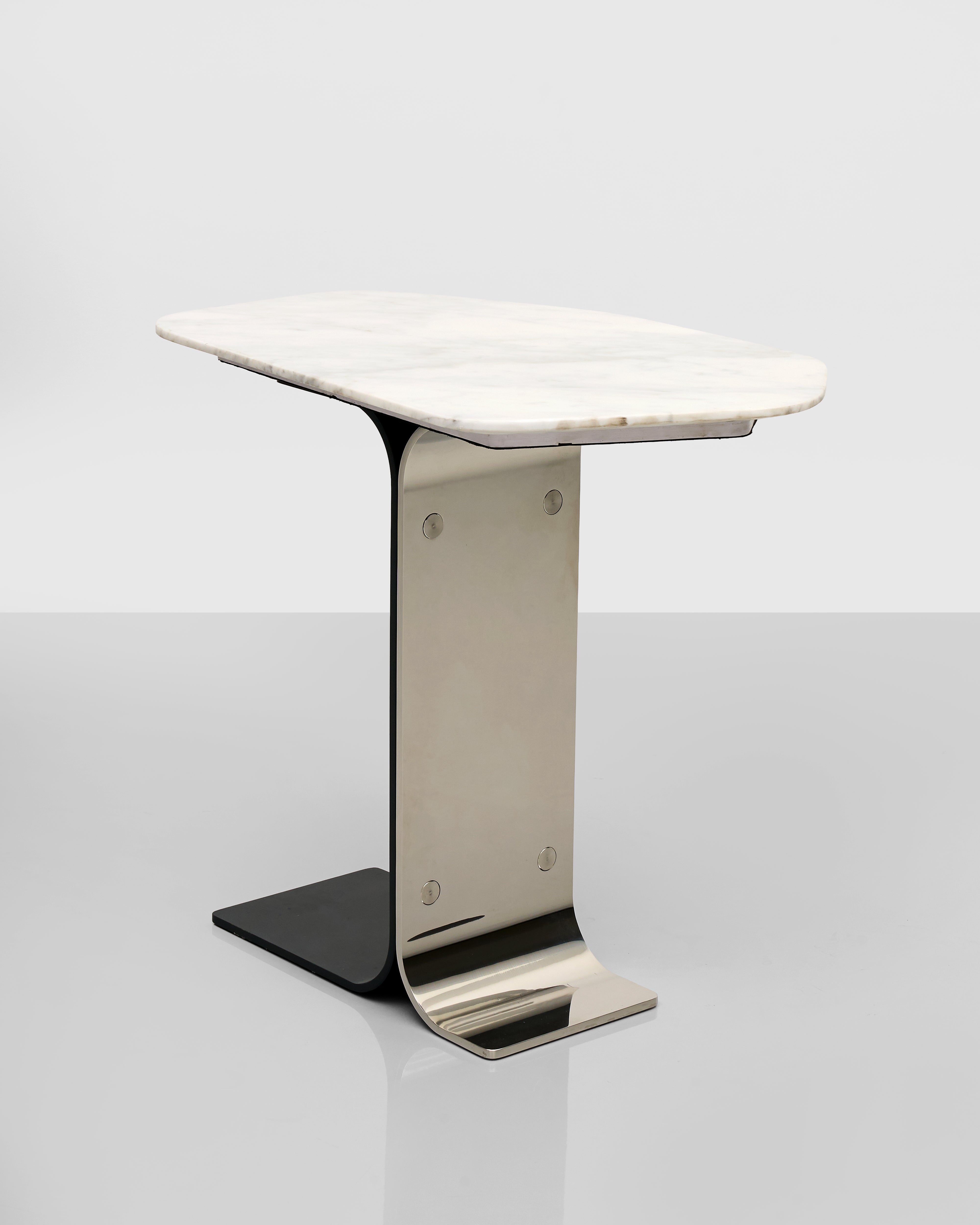 Small marble table with a metallic base on a light gray background