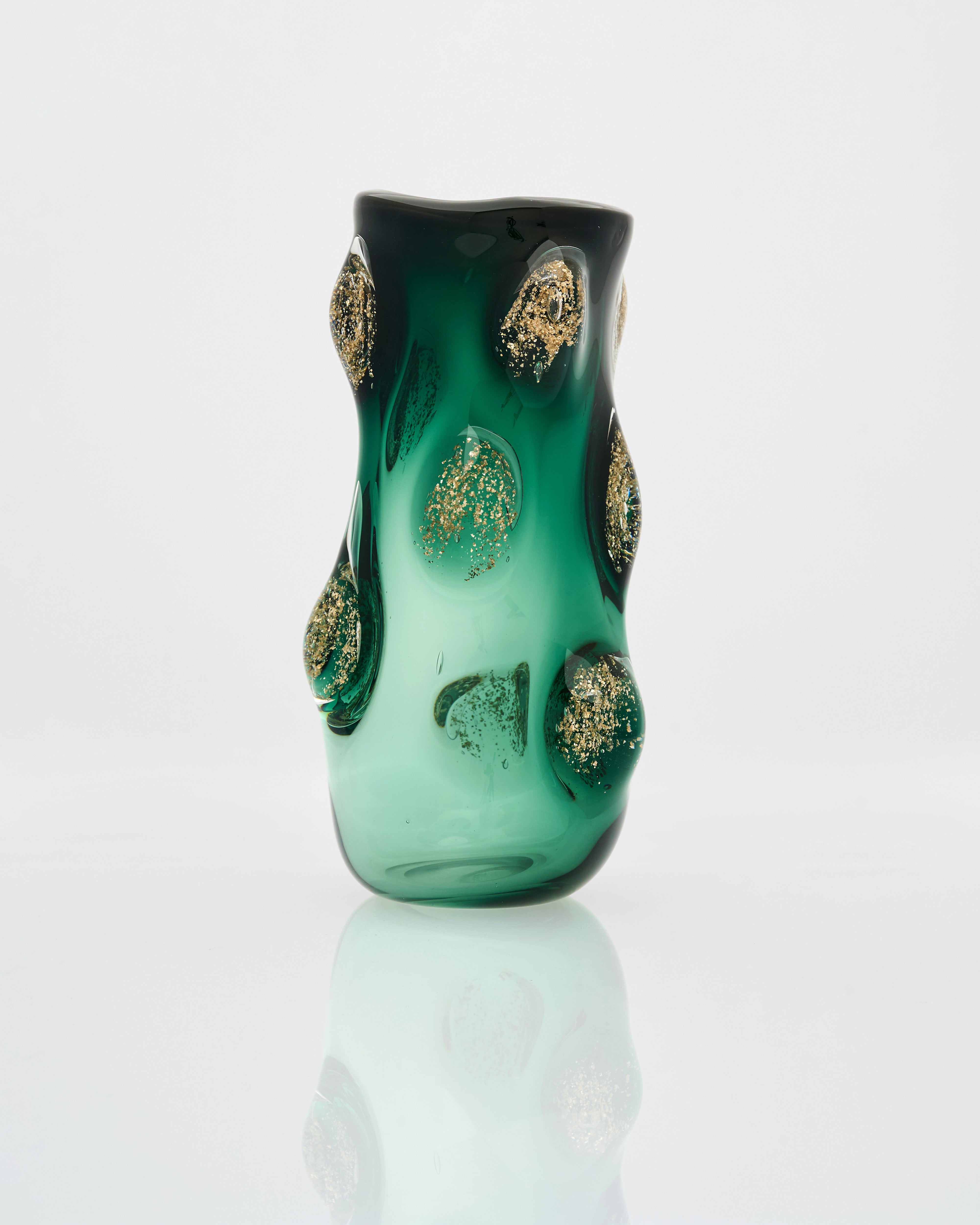 Green glass vase with gold leaf patterns on a white background