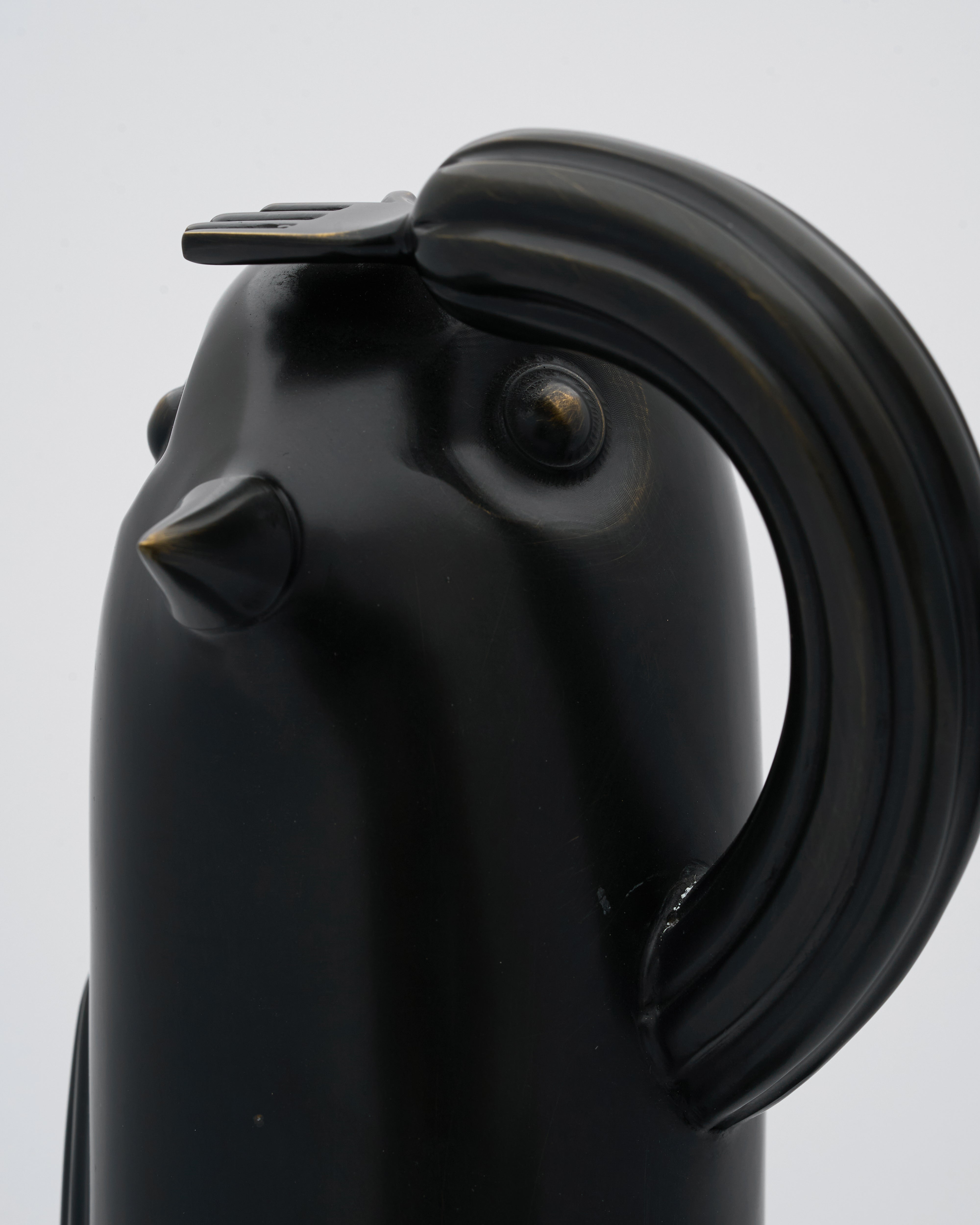 Black ceramic chicken-shaped bird figurinee on a light gray background