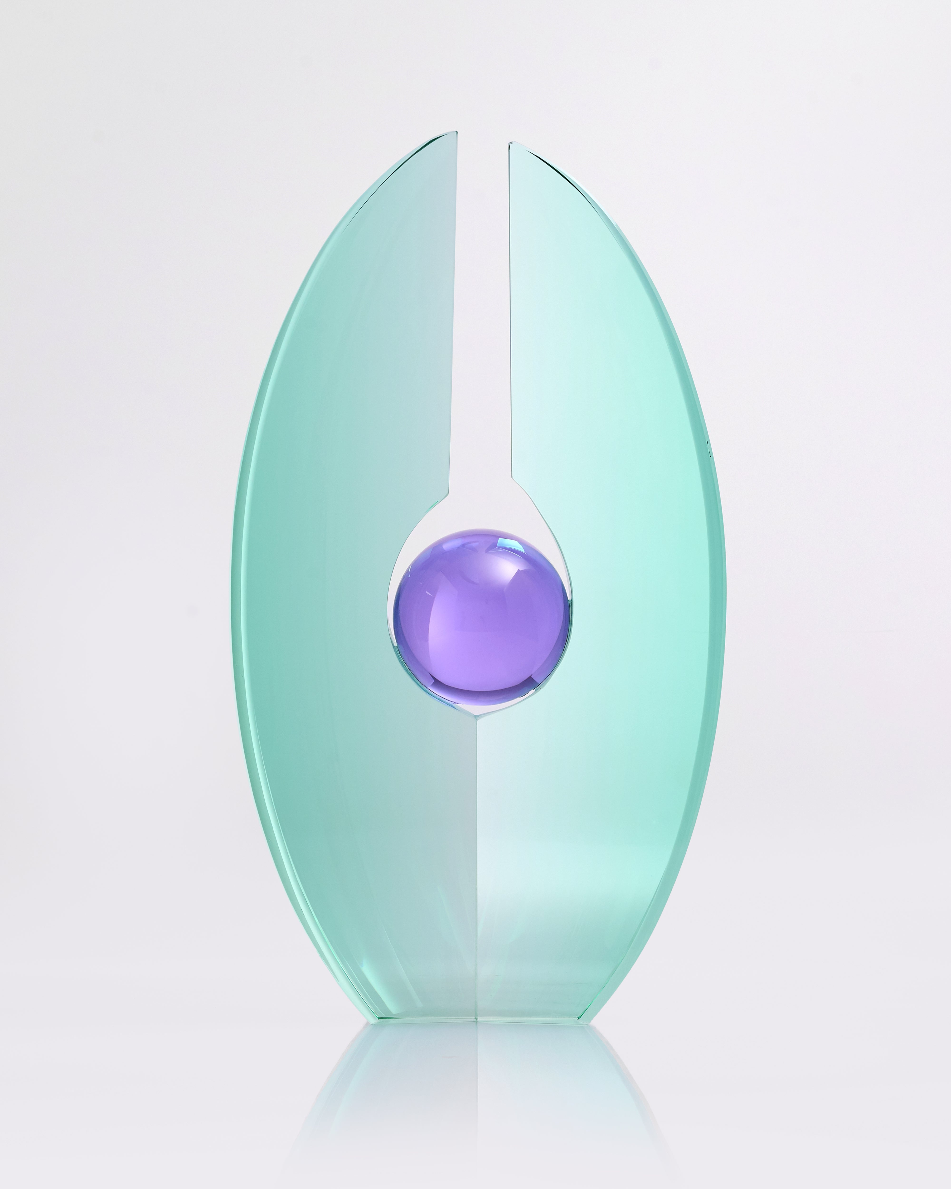 Decorative object with a light green oval shape and a purple sphere in the center on a white background
