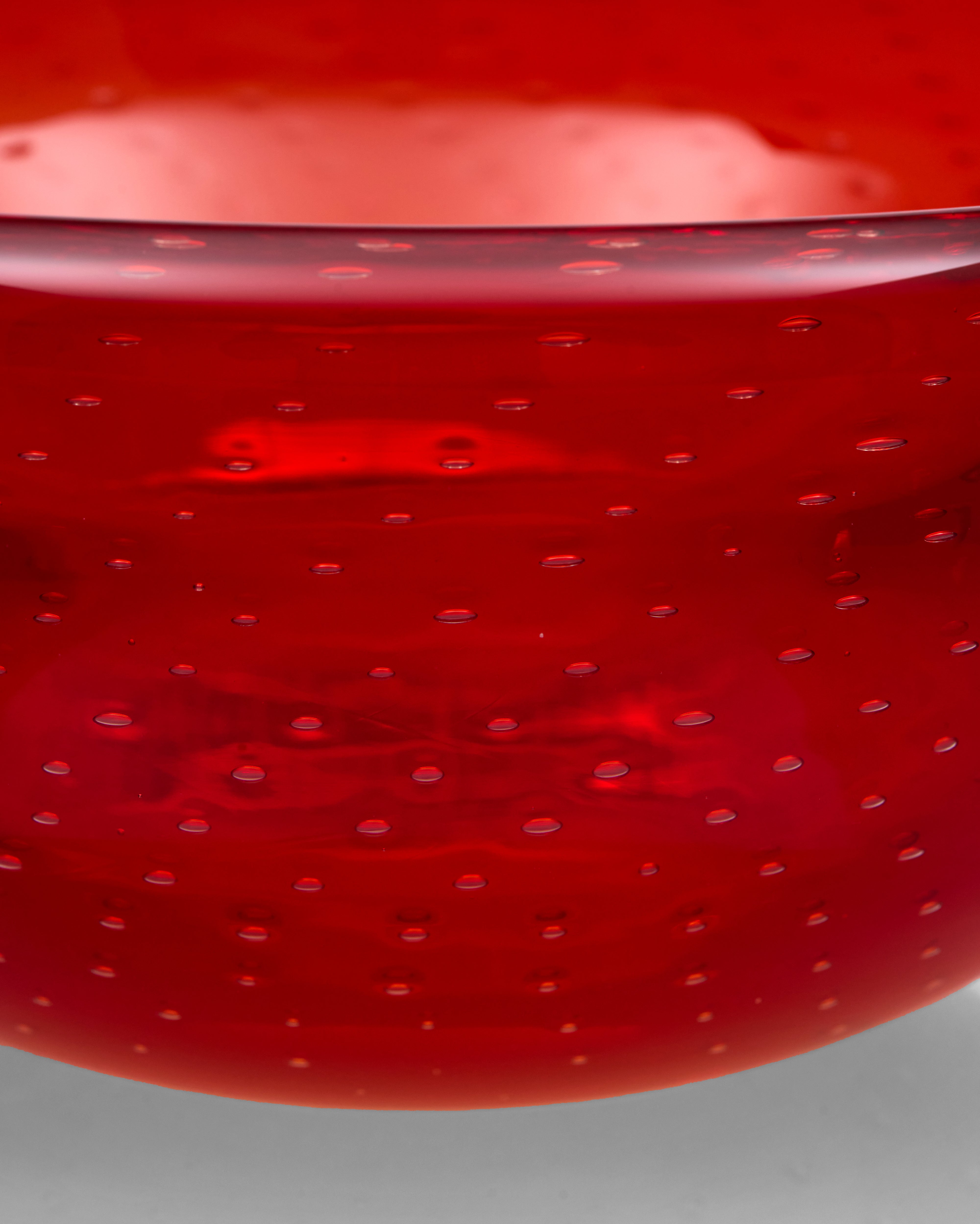 Close-up of a red glass bowl with a textured surface
