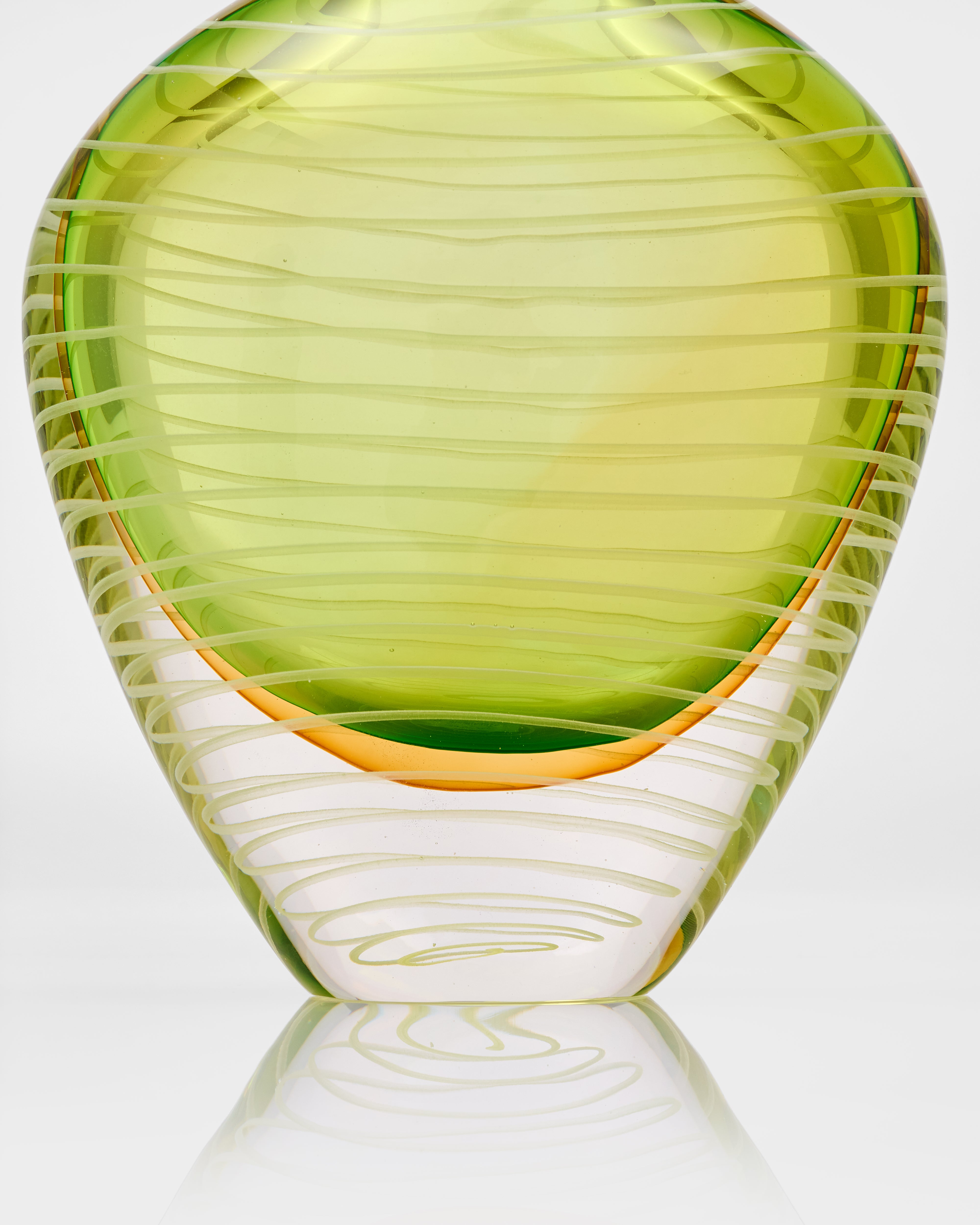 Green glass vase with ribbed texture on a white background