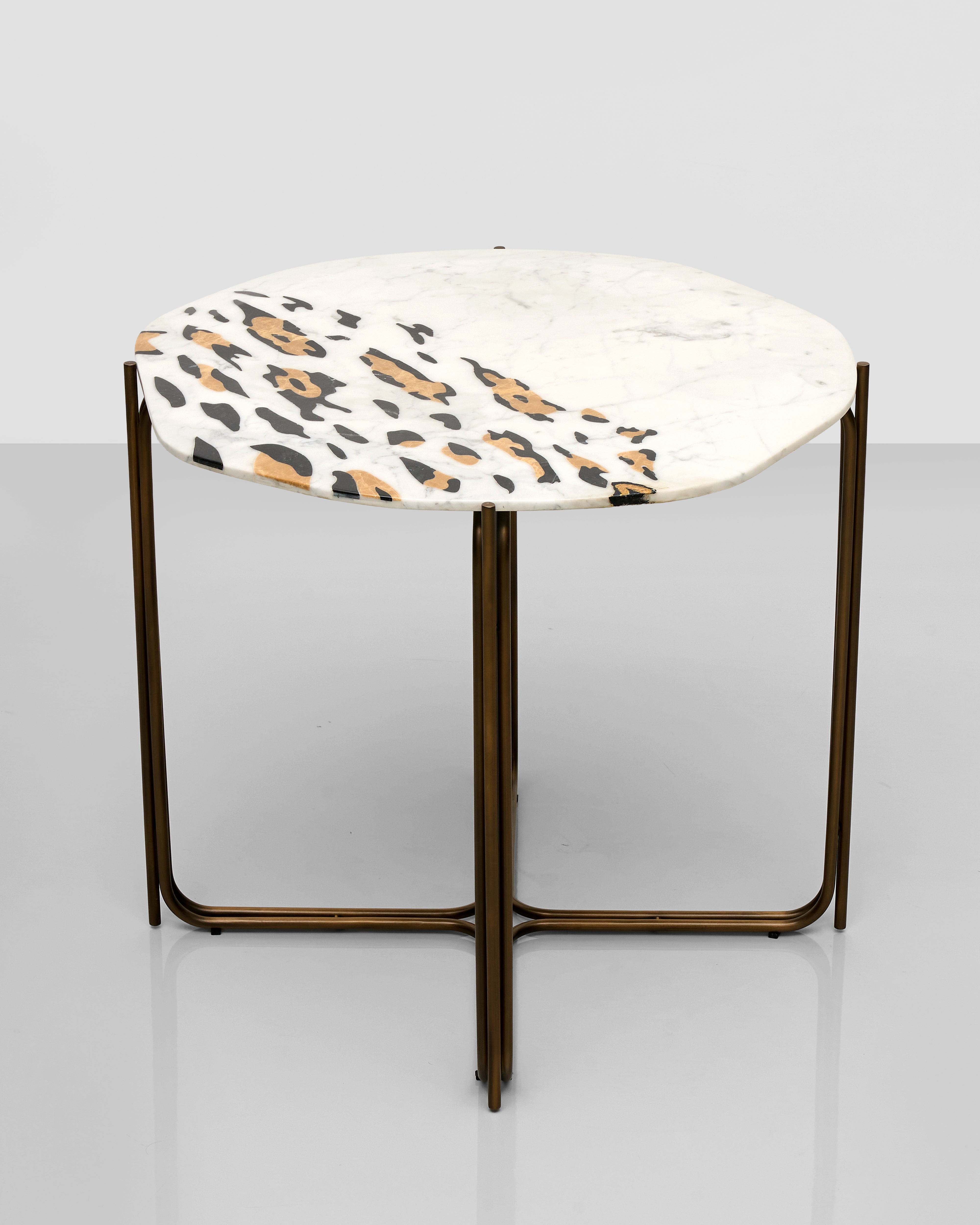 Round side table with a marble-like top and bronze frame on a light gray background