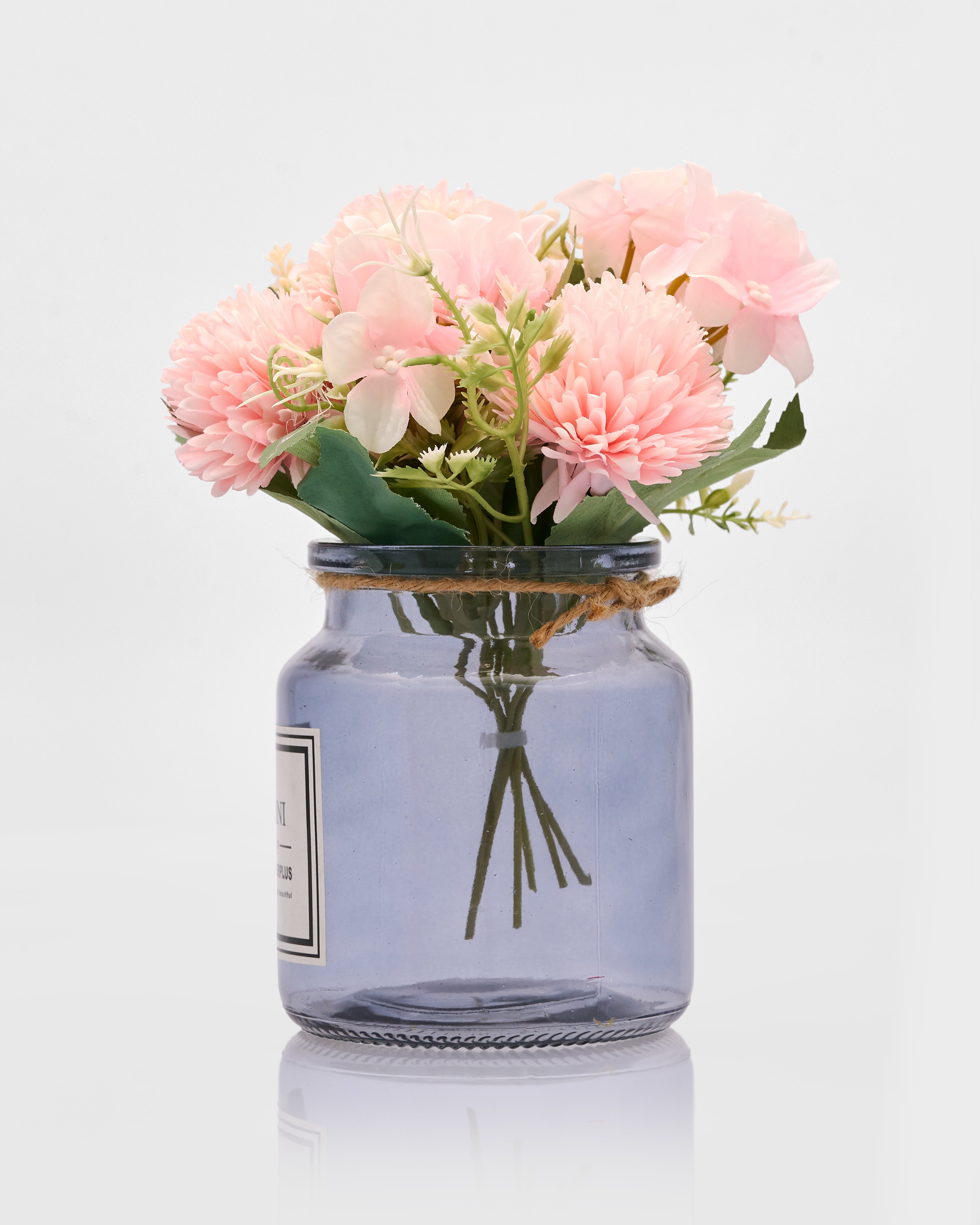 Clear glass jar with pink flowers on a white background