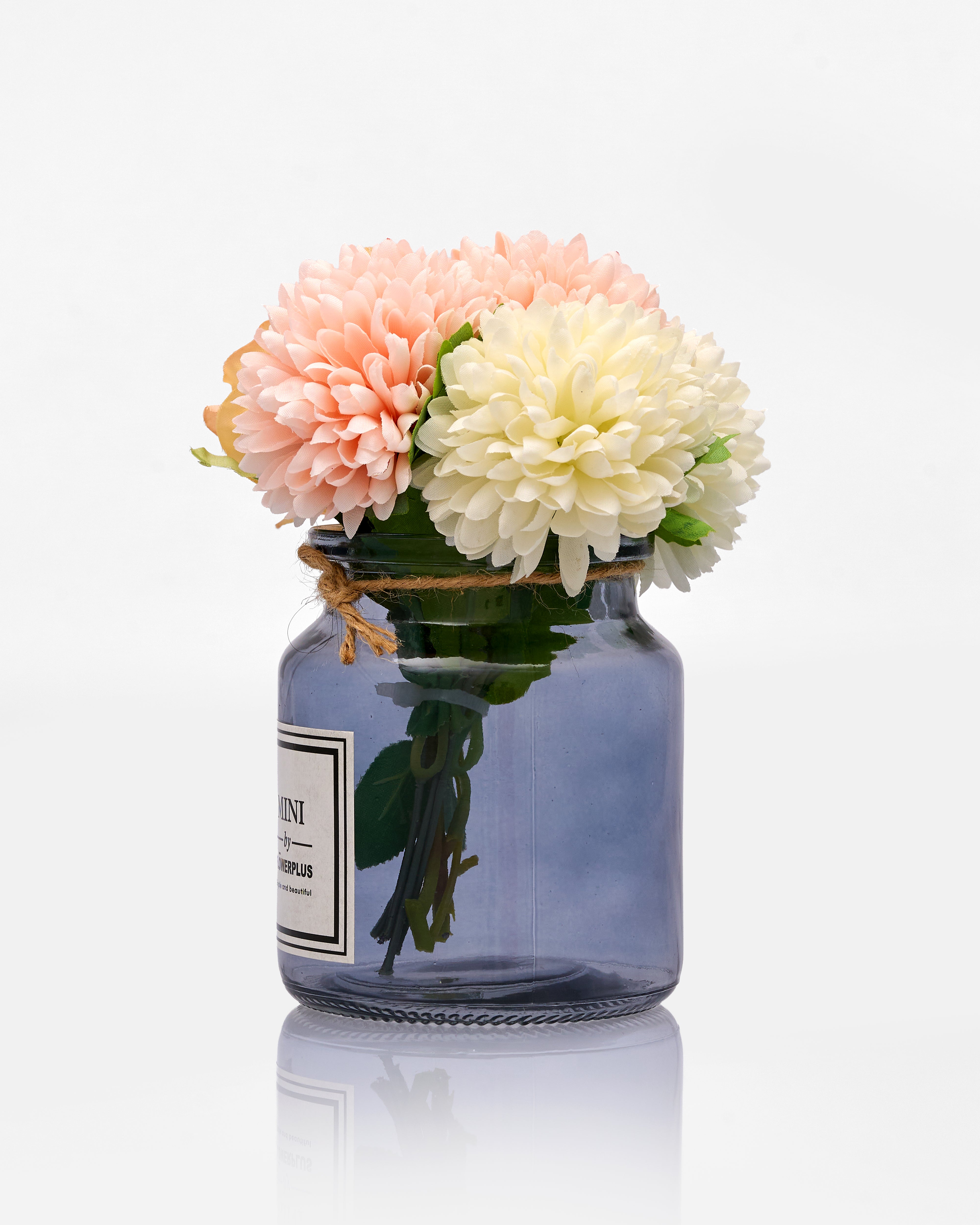 Glass jar with pink and white flowers on a white background