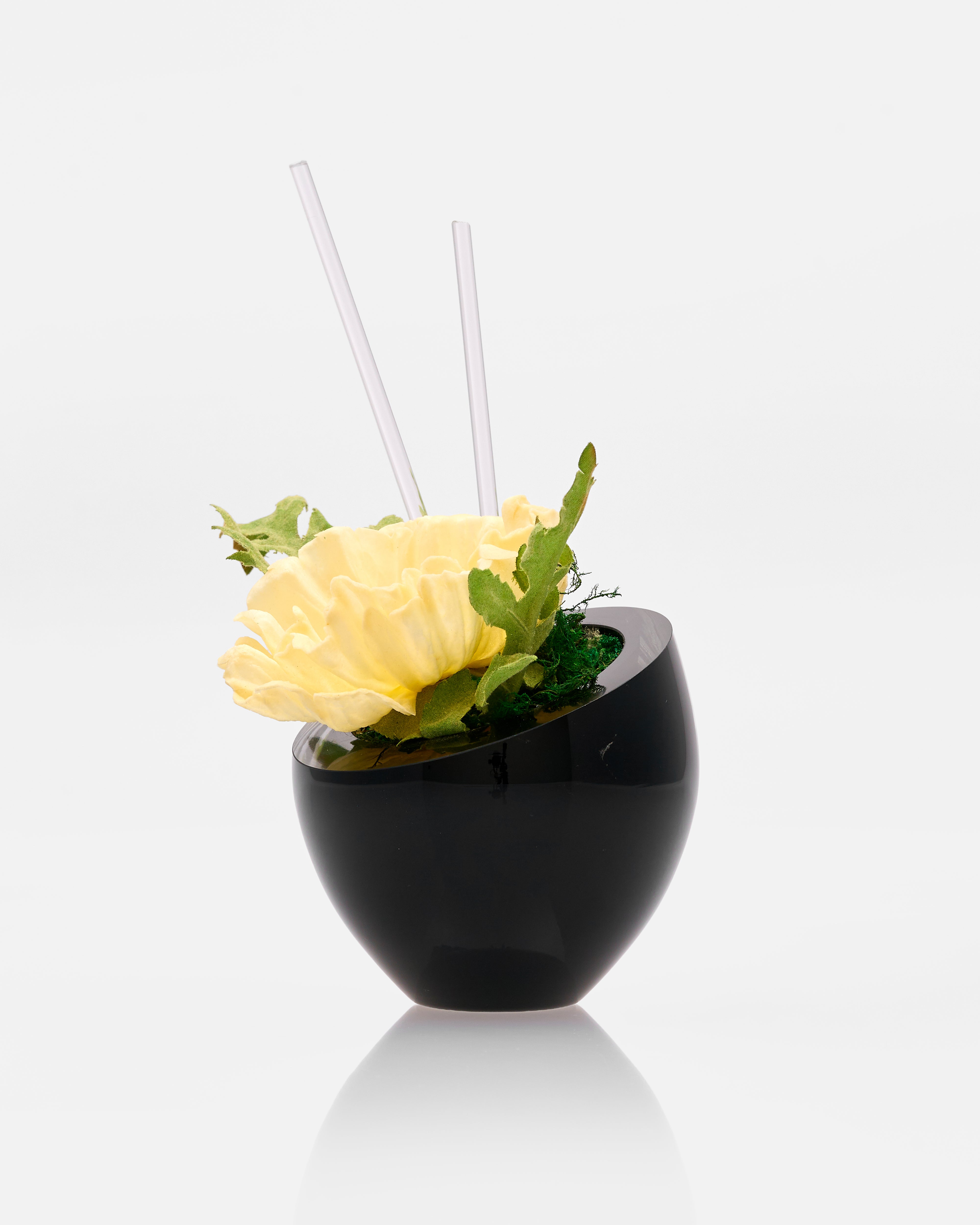 Decorative flower arrangement in a black vase on a white background