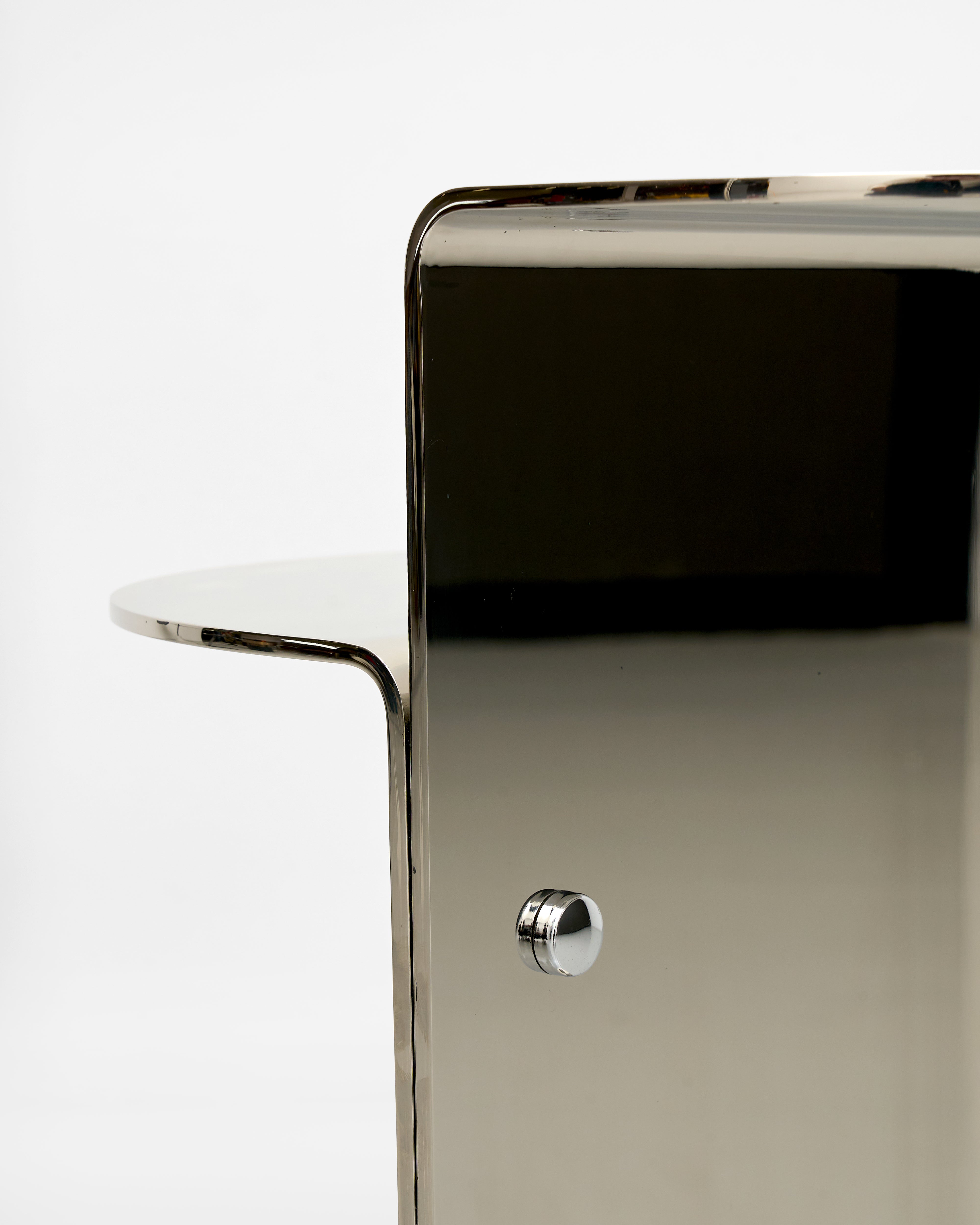 Close-up of a modern side table with a metallic finish on a white background