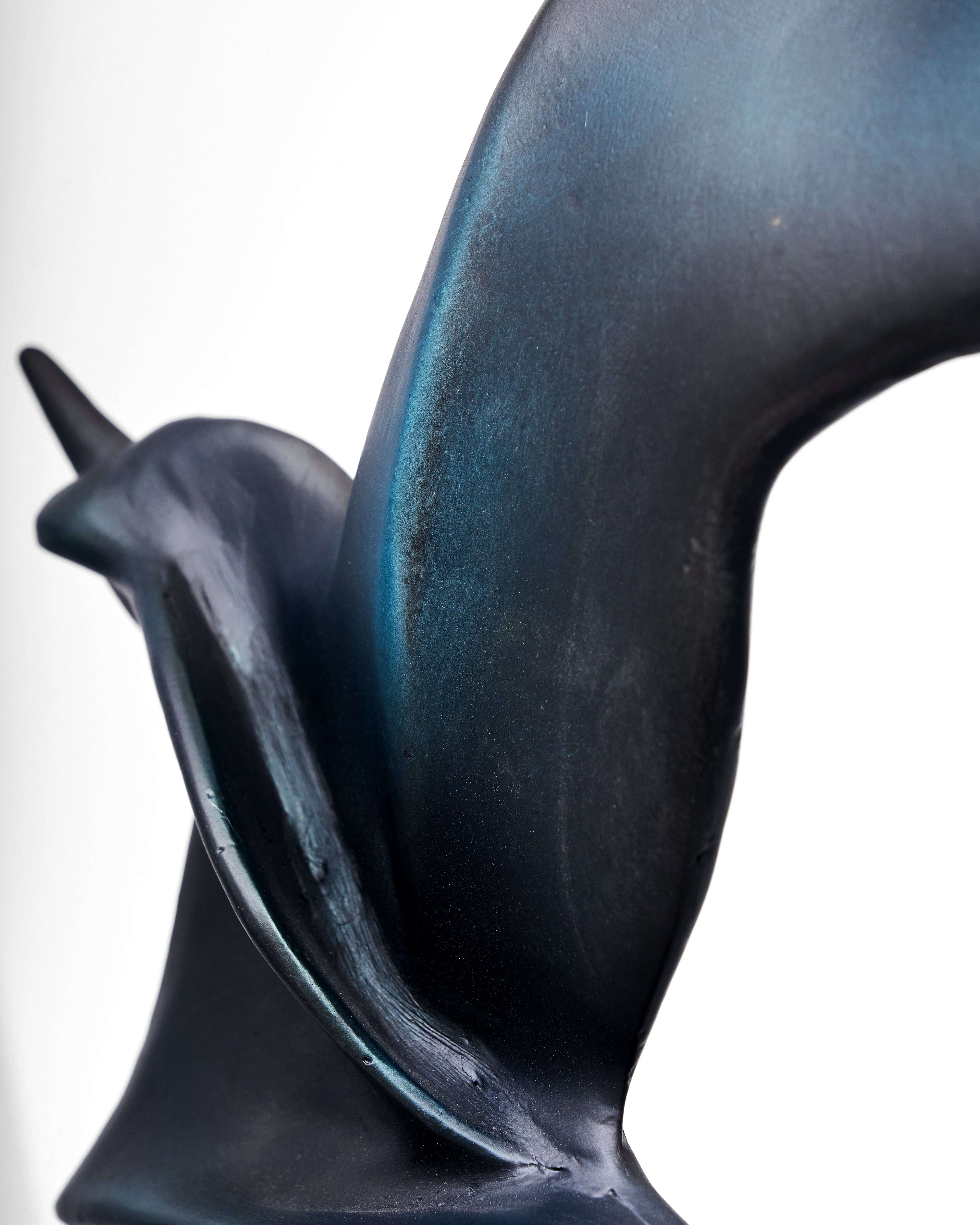 Black ceramic sculpture of a snail on a white background