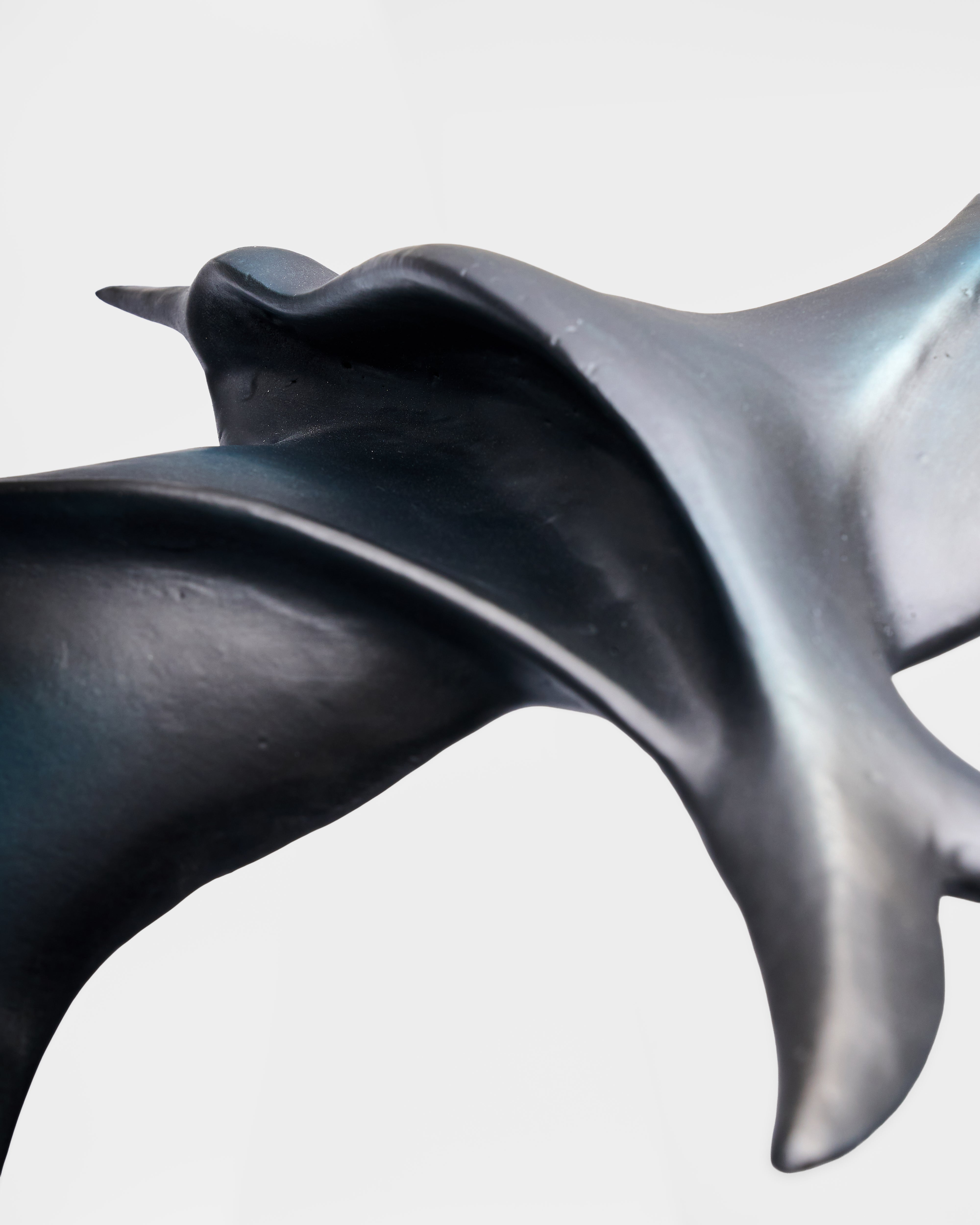 Abstract sculpture of a bird in flight on a light gray background