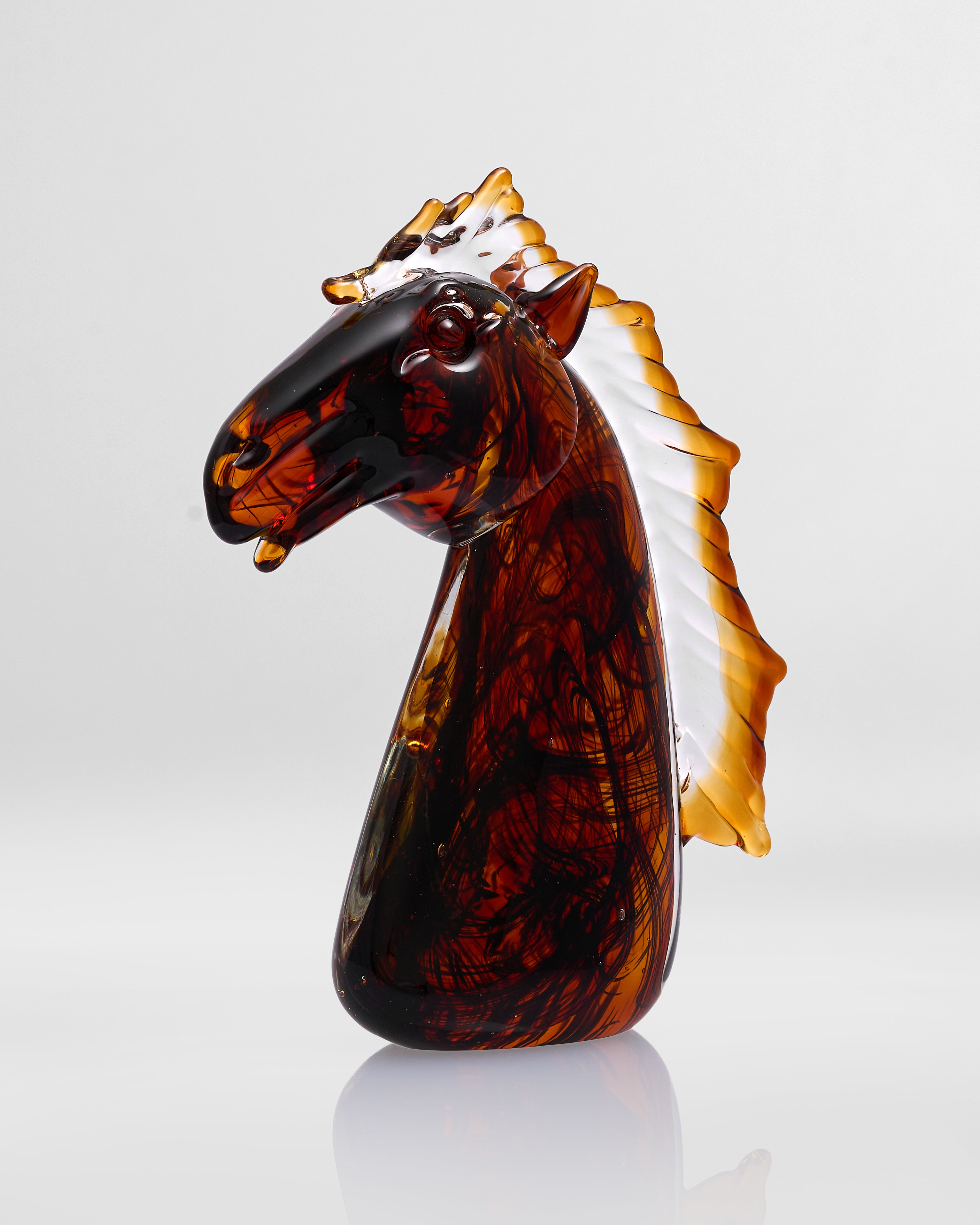 Tortoiseshell horse head figurine on a white background